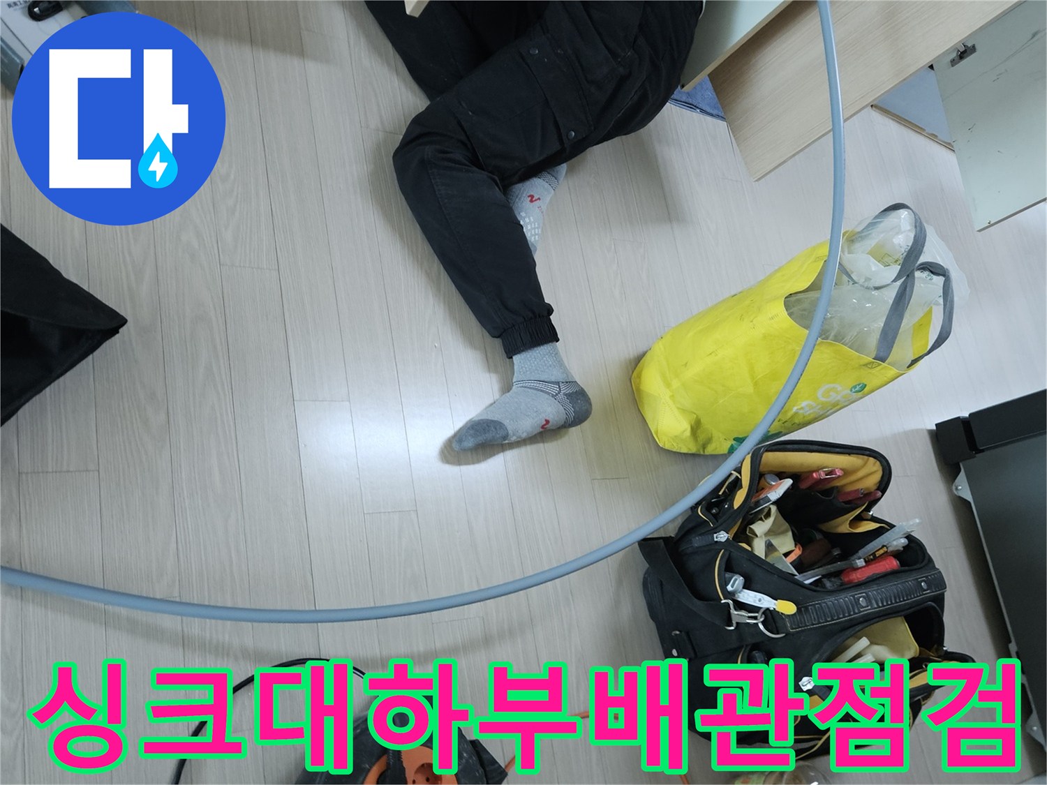 싱크대 하부장 주변에서 진행 중인 배관 점검 모습입니다.