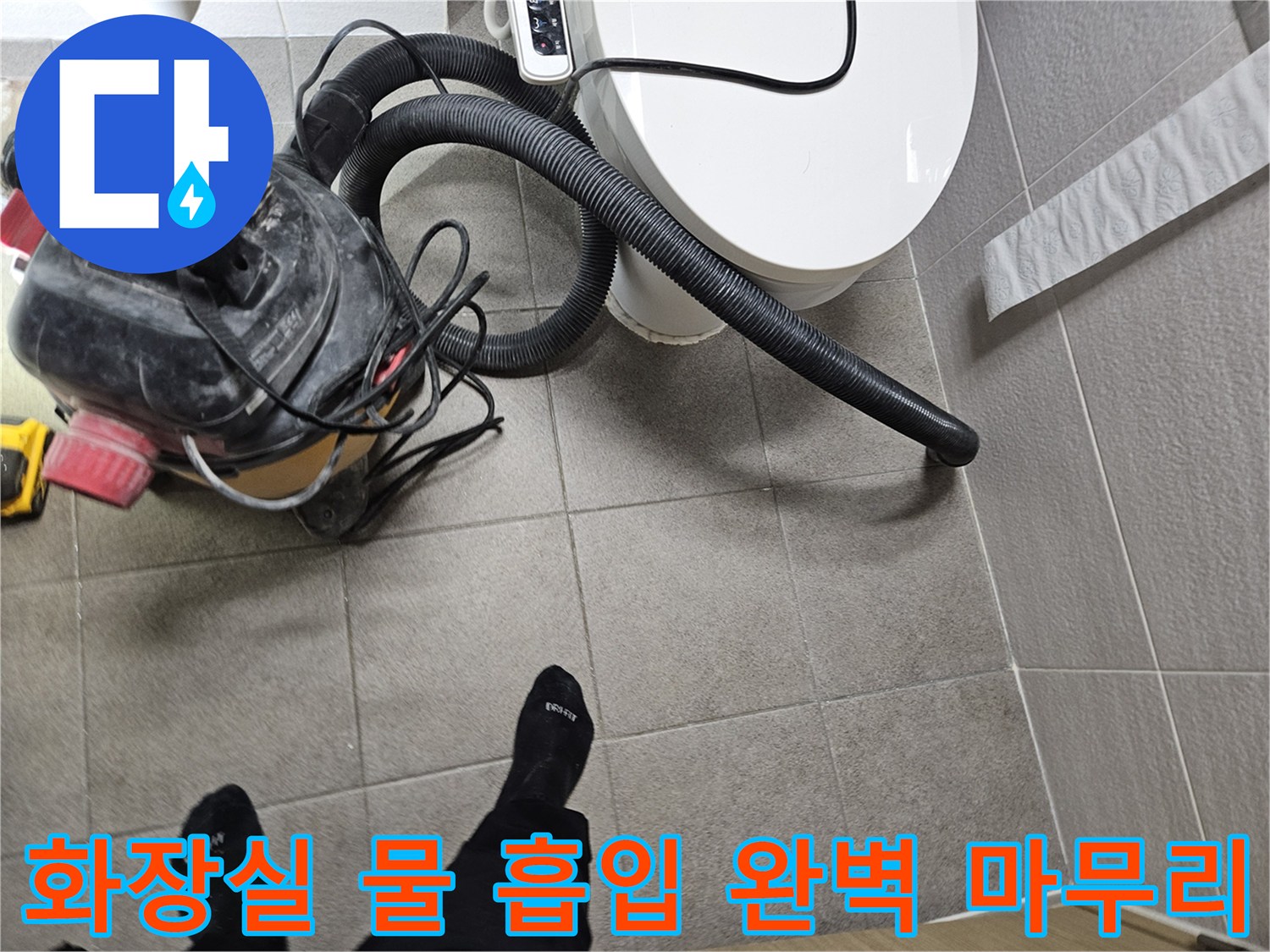 오산시 고객 댁 화장실에서-누수 엔지니어가-변기 주변의 물을-습식 청소기로 흡입하여-누수 공사의 완벽한 마무리를 준비하는 모습