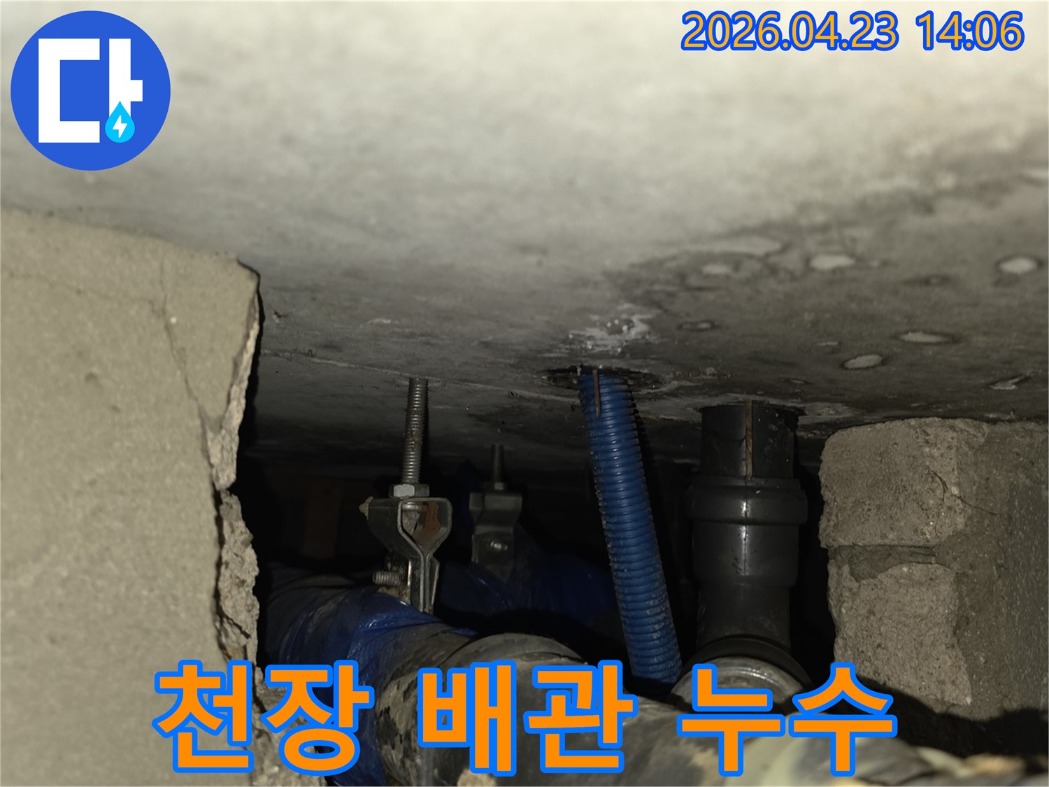 천장 속 복잡하게 얽힌 배관들 사이에서-누수로 인해 젖은 부위를 포착한 사진