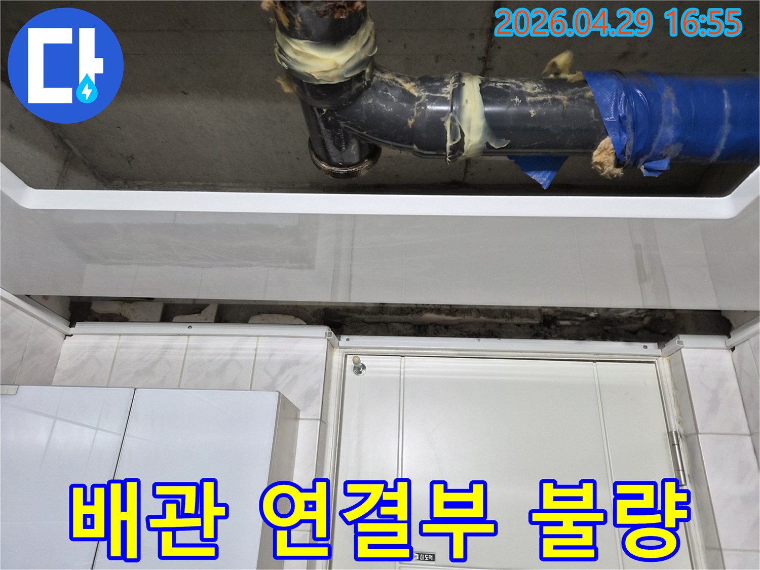 도봉구 아파트의-천장 배관 연결부에서-누수가 발생한 현장입니다-불량 시공으로 인한 손상과-임시 보수 흔적이 보입니다.