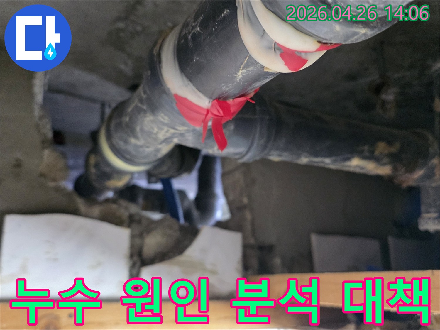 이 이미지는 아파트 배관에서-누수 원인을 분석하고-빨간 테이프로 표시된 지점을 중심으로-대책을 마련하는-전문가의 모습을 보여줍니다.