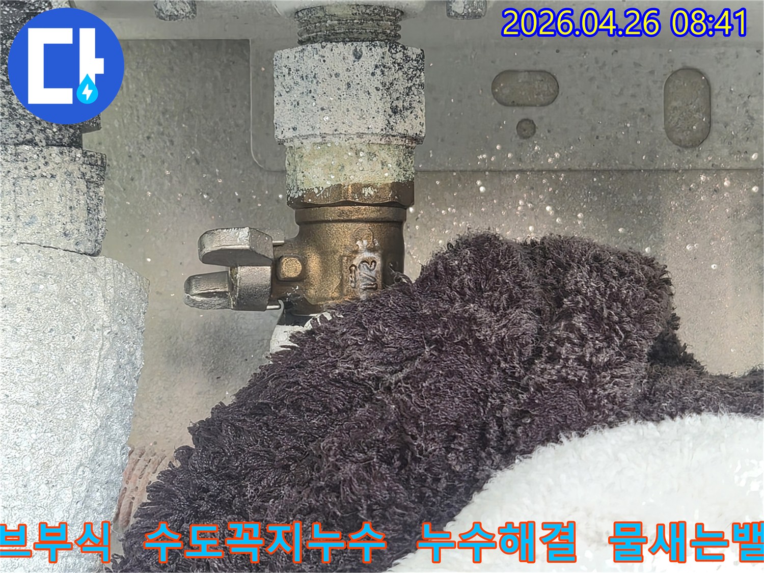 부식으로 인해 하얗게 변색된 수도 밸브에서 물이 새고 있는 현장-아래 수건이 젖어있는 모습-수도꼭지 누수 해결을 위한 진단 사진