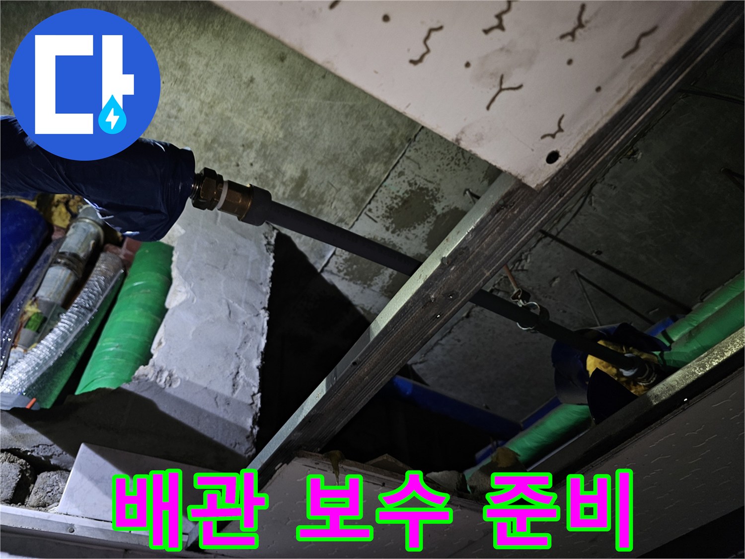 누수 발생 배관의 연결 부위를 보수하기 위해 주변을 정리하고 준비하는 현장입니다.