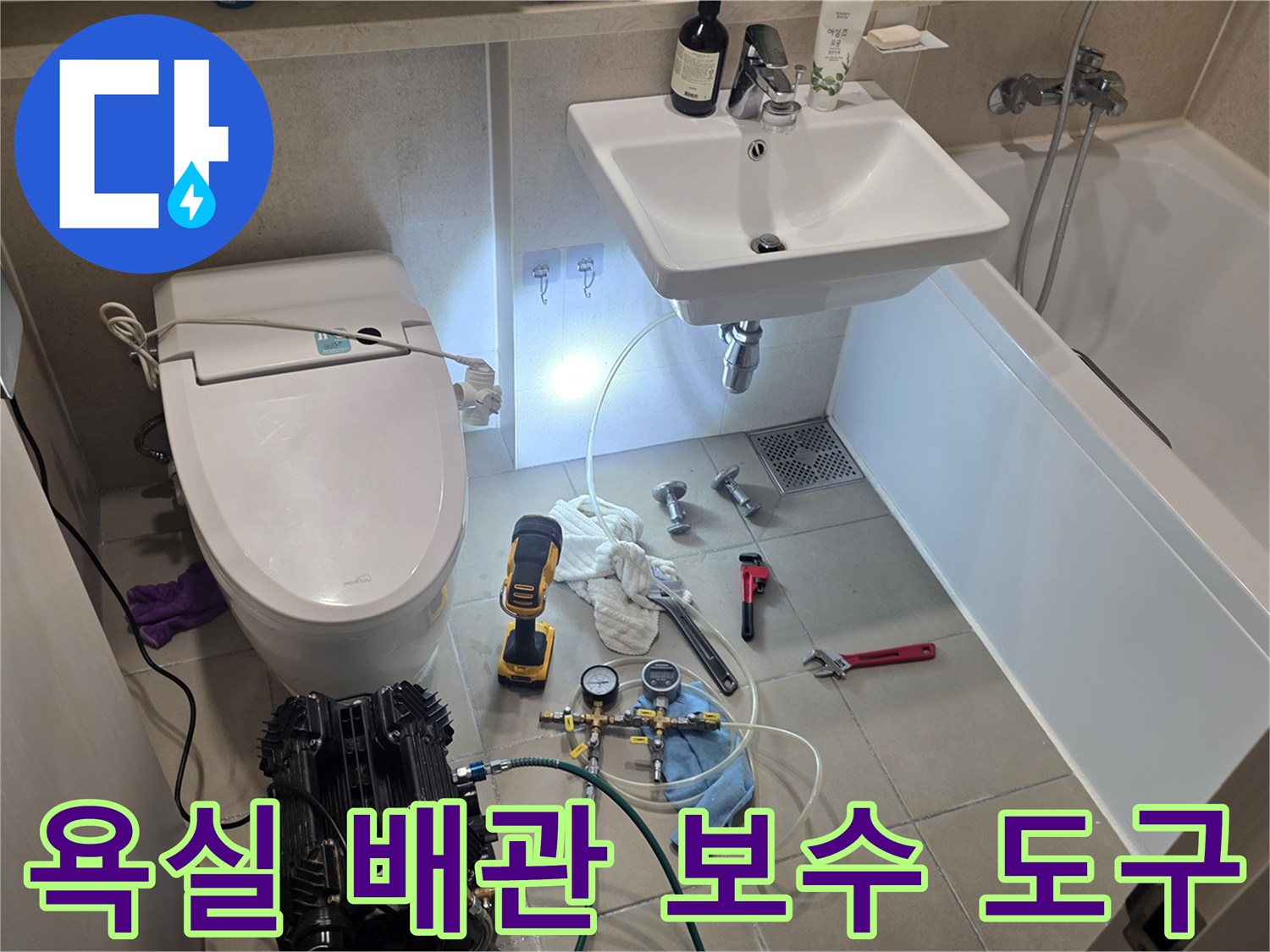 수리 작업을 위해 세면대 아래 배치된 몽키스패너와 전동드릴