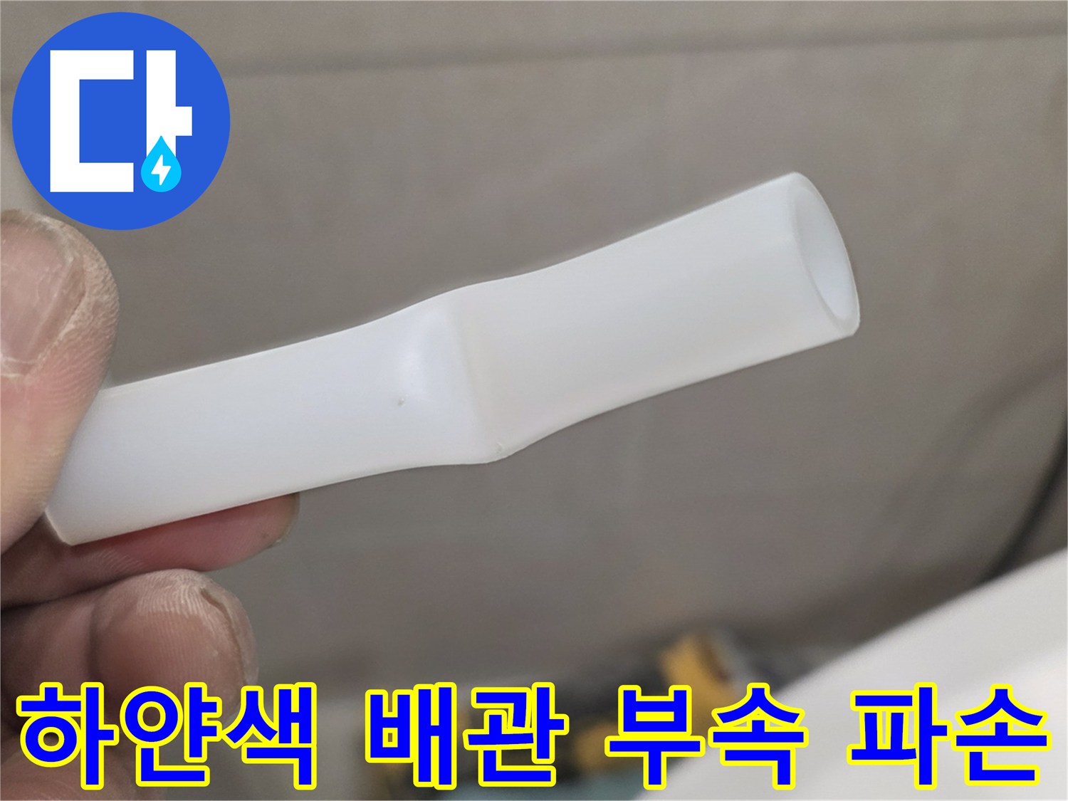 작업자가 손에 들고 있는 깨진 하얀색 플라스틱 배관 소켓