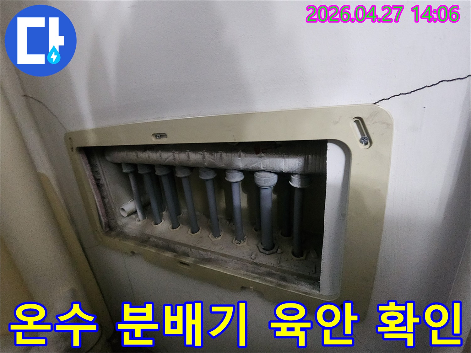 온수-배관과-연결된-수도분배기의-외관을-육안으로-점검하는-모습입니다.