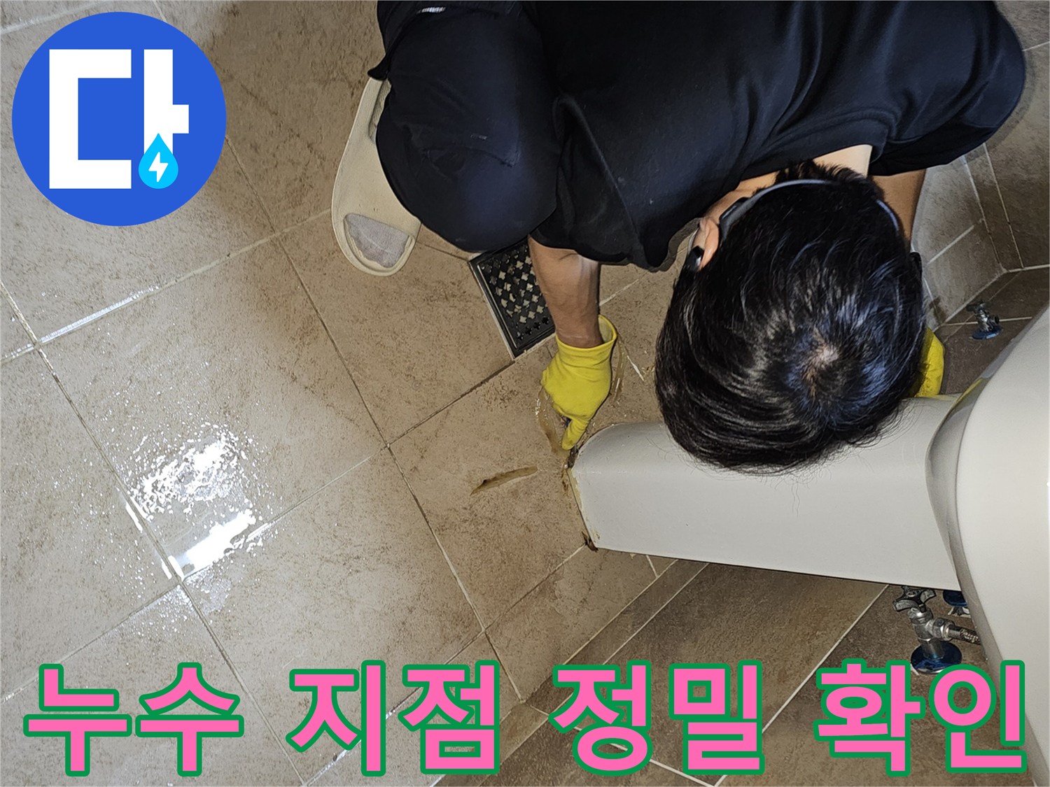 누수 전문가가-젖어있는 욕실 바닥 타일과-세면대 하단부를-집중적으로 살펴보며-누수 지점을 특정하고 있습니다