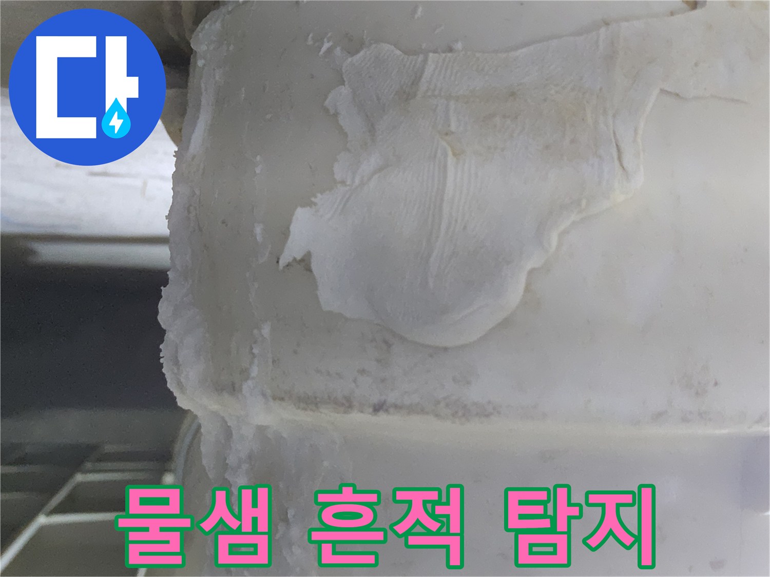 배관에서-물이 새면서-생긴-하얀-석회질 침전물과-함께-오염된-천 조각이-붙어있는-누수 현장의-사진입니다.
