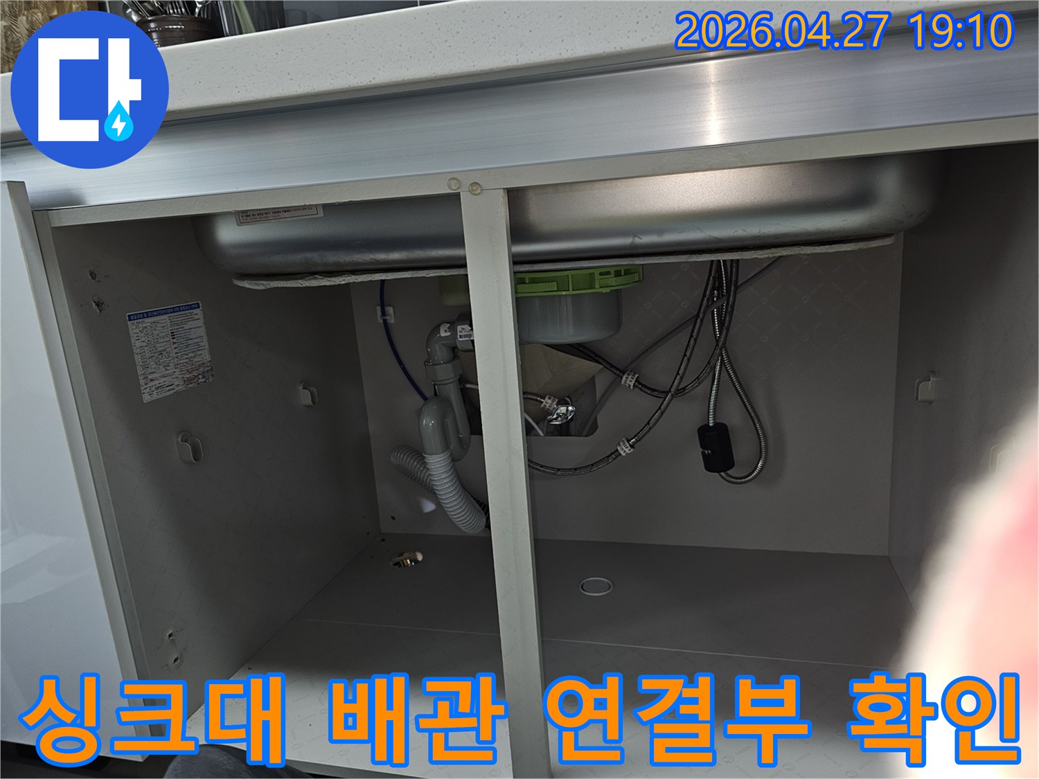 주방 싱크대 하부의 배관 연결 부위를 근접 촬영한 이미지로-누수 발생 가능성이 높은 지점을 집중적으로 점검하고 있습니다.
