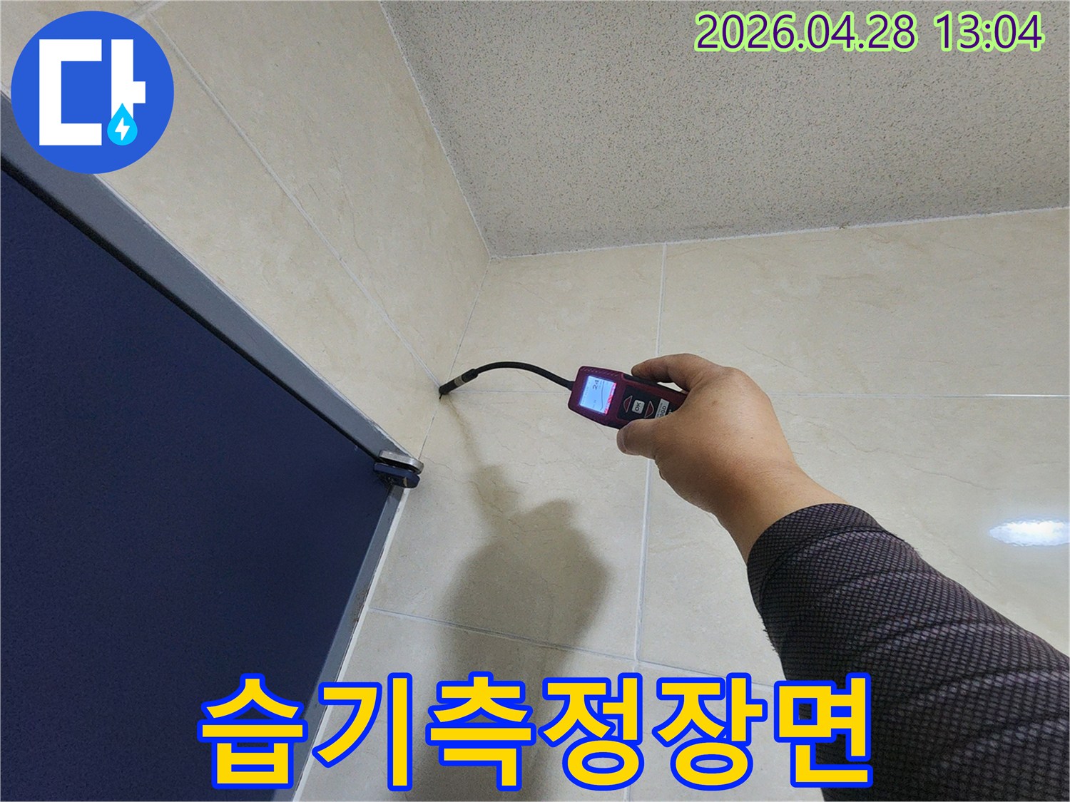 숙련된 누수 전문가가-첨단 장비를 활용하여-욕실 벽면과 바닥 경계의-미세한 누수 흔적을-꼼꼼히 확인하고 있습니다