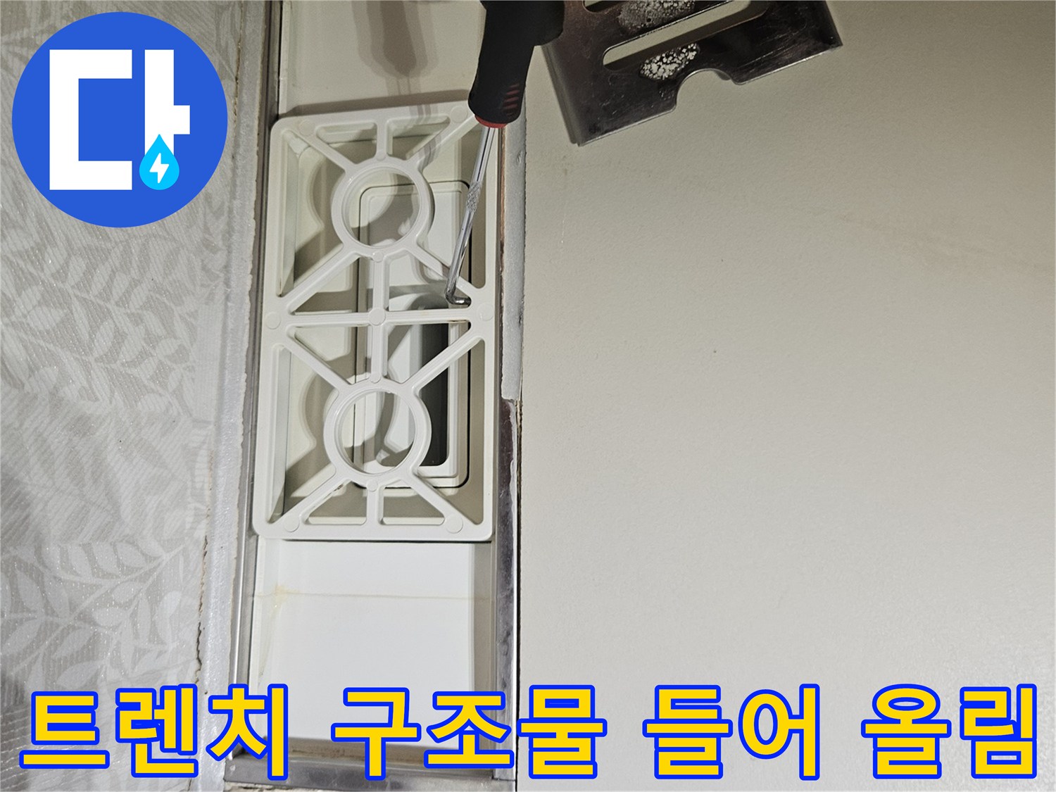 욕실-트렌치-내부-구조물을-드라이버로-조심스럽게-들어-올려-누수-여부를-확인하는-전문가의-손길