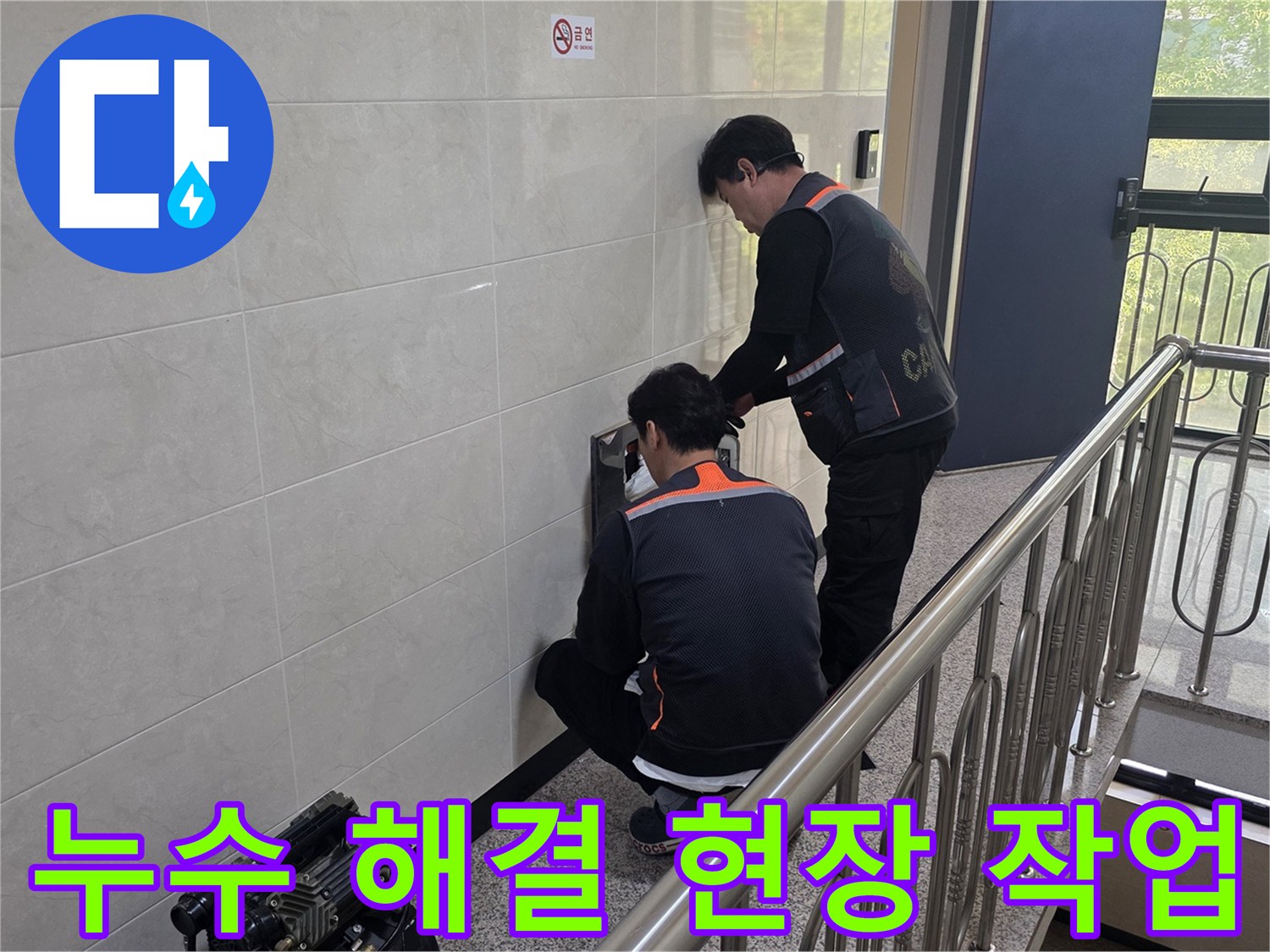 두 명의 전문 기술자가 건물 벽면의 누수 의심 지점을 정밀하게 탐지하며 신속하고 확실한 문제 해결을 위한 준비를 하고 있습니다.