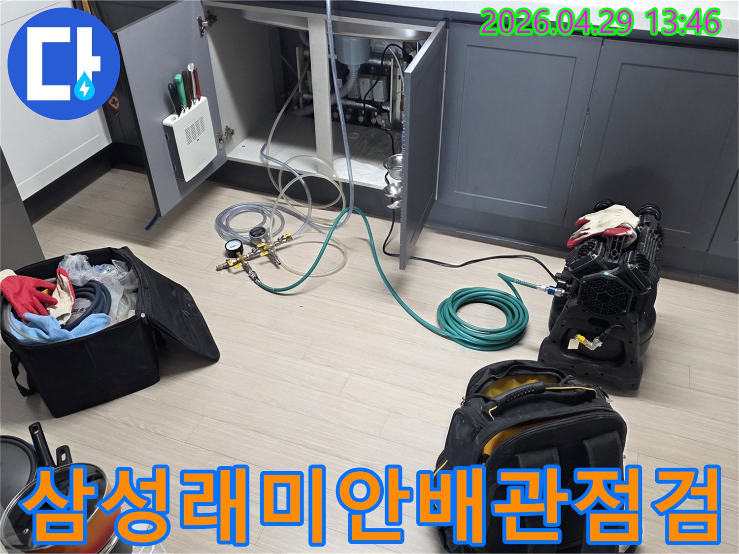 안양 비산 삼성 래미안 아파트의 주방에서-싱크대 하부 누수 확인을 위한-배관 점검 장비와-호스를 연결하여-테스트를 준비하는 모습입니다