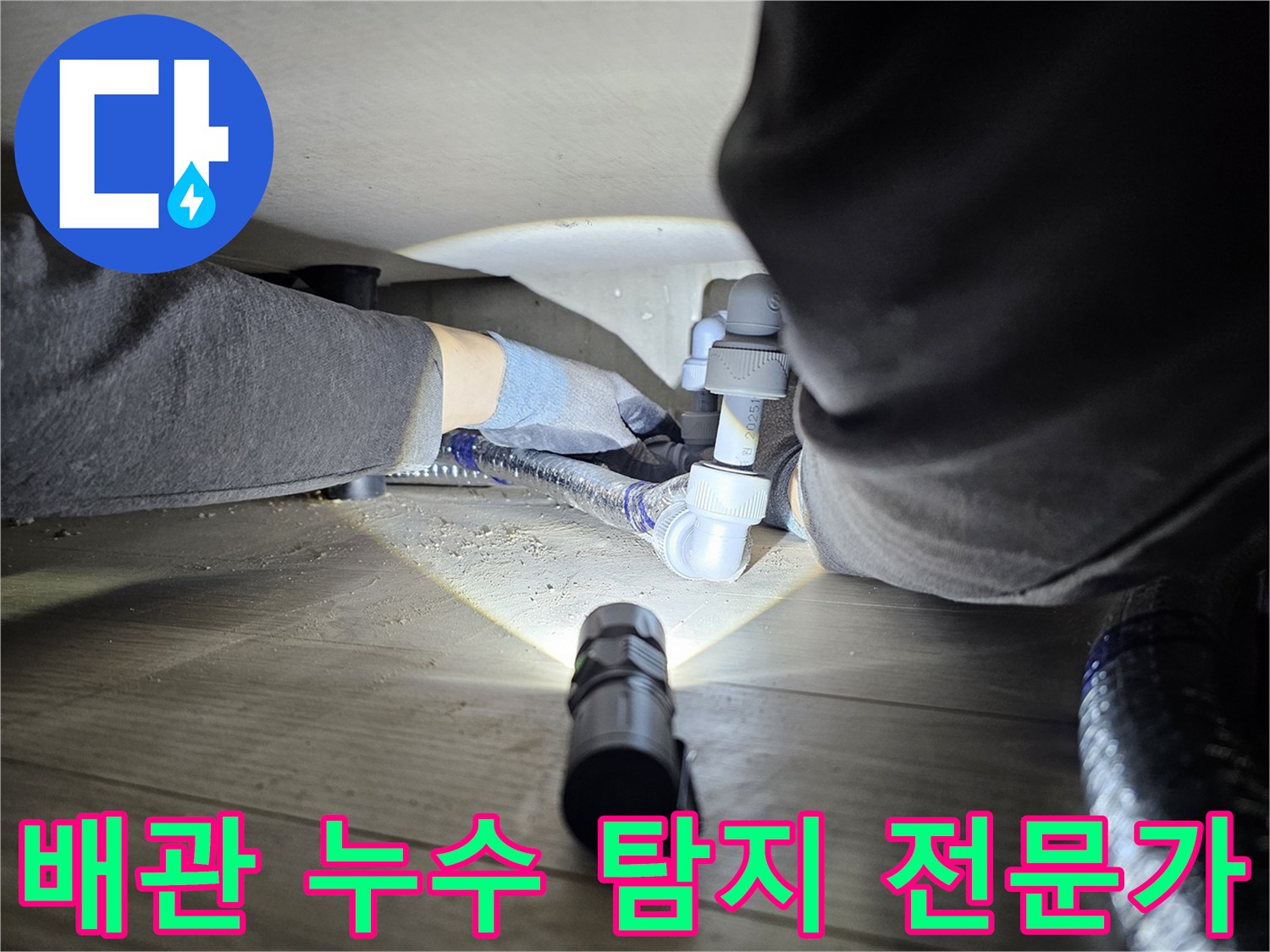 누수-탐지-전문가가-어두운-공간에서-배관-연결부를-확인하는-모습