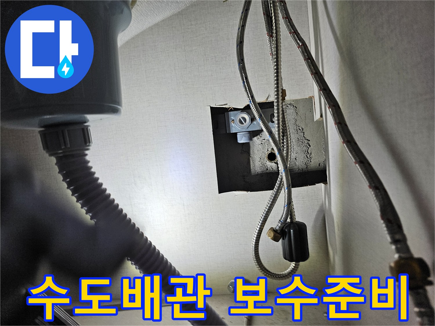 싱크대 하부장 내부의-수도 배관 연결 부위를-점검하고-보수를 준비하는 모습입니다.