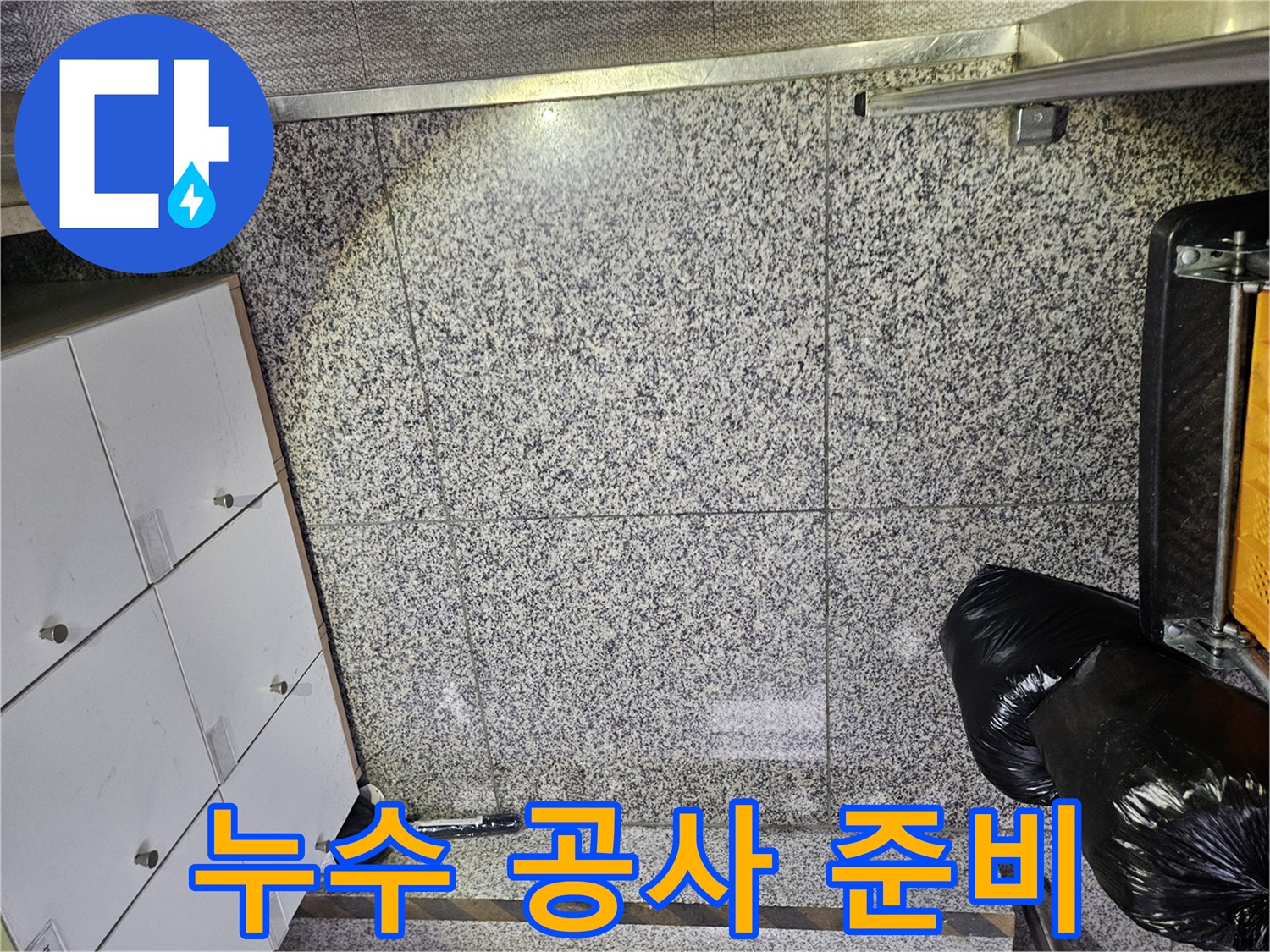 포천 아파트의 바닥 타일에서-누수로 인한 물기 흔적을 발견하고-정확한 누수 지점을 찾기 위한-전문가의 면밀한 점검이 이루어지고 있습니다