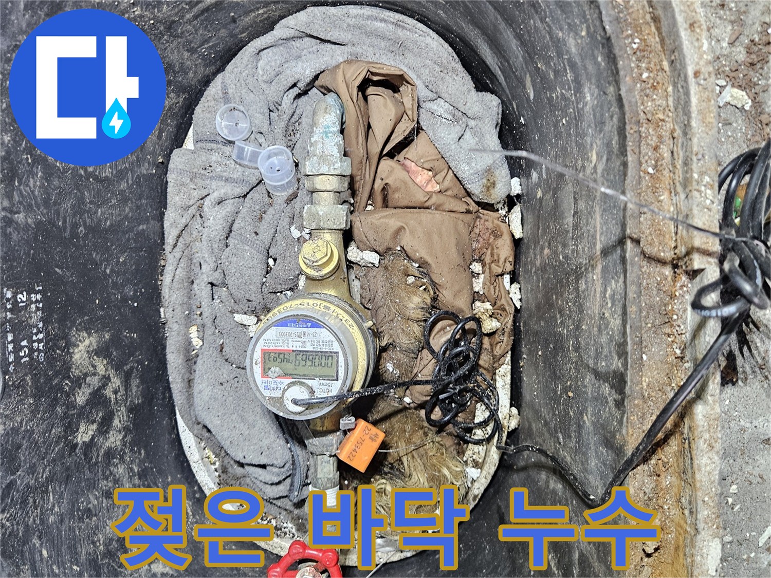 계량기함 주변 바닥이 물에 젖어 있는 모습으로-오랜 시간 누수가 진행되었음을 시사합니다