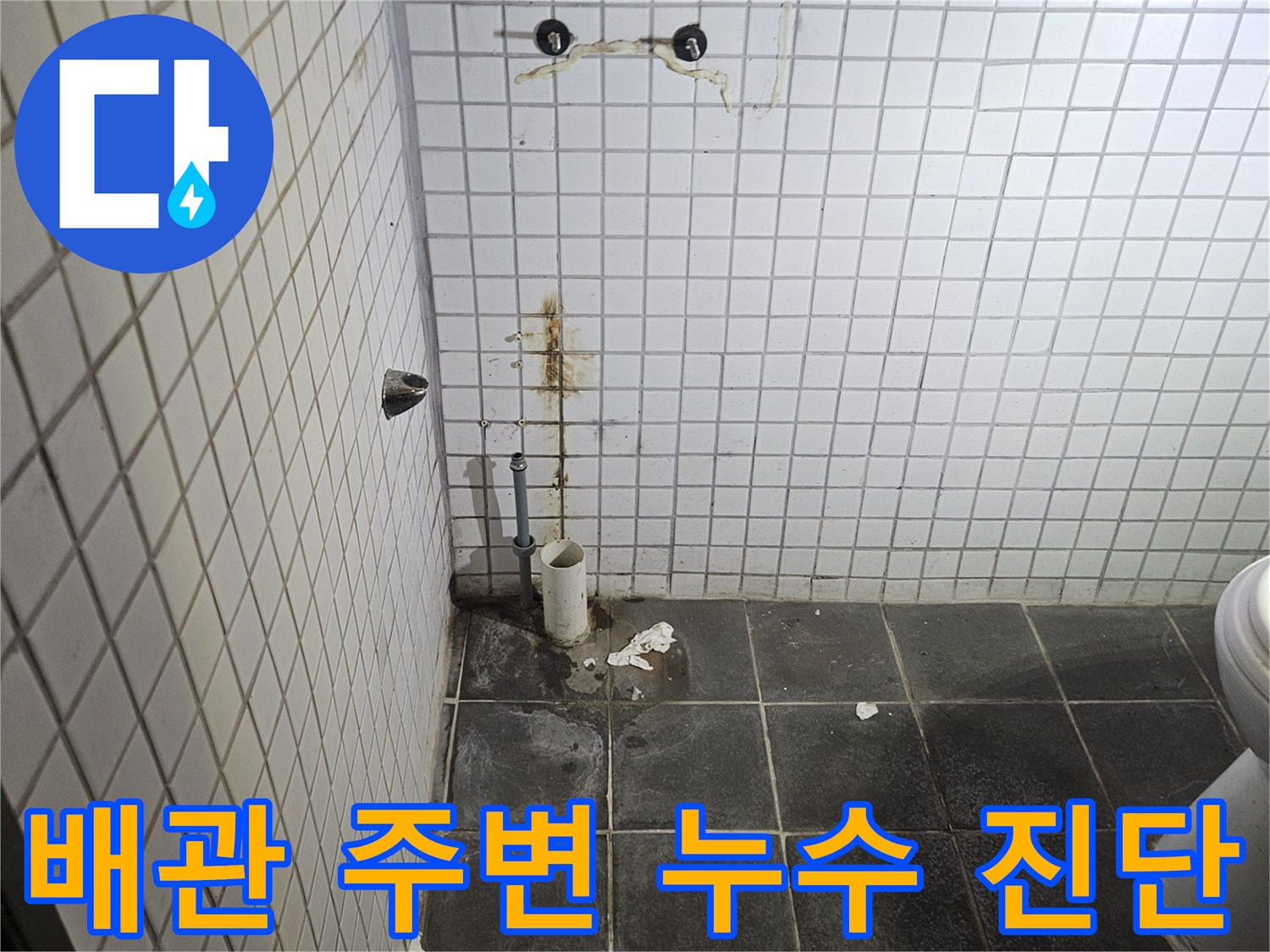 세면대 탈거 후-욕실 바닥에 노출된-하수 배관과-주변 타일의-누수 흔적을-정밀하게 검사하는-누수 전문가