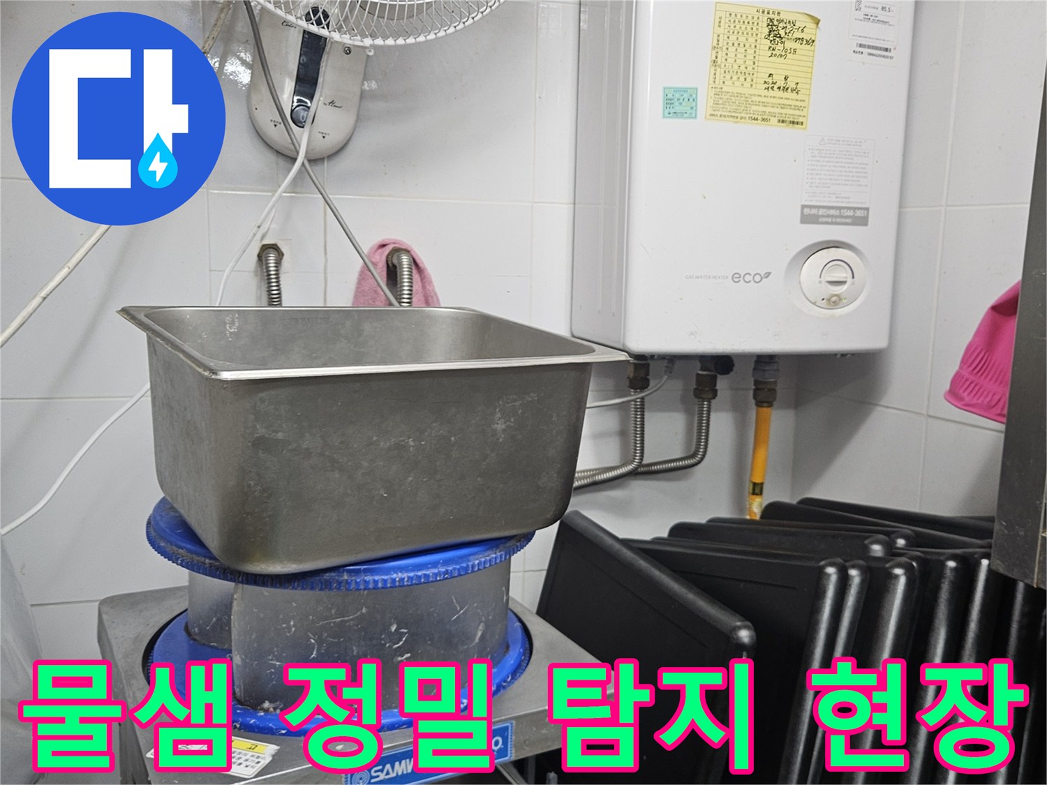 이 이미지는 보일러와 싱크대-그리고 다양한 배관이 있는 공간에서-물샘 현상의 원인을 찾기 위해 정밀 탐지 작업을 수행하는 모습을 담고 있습니다.