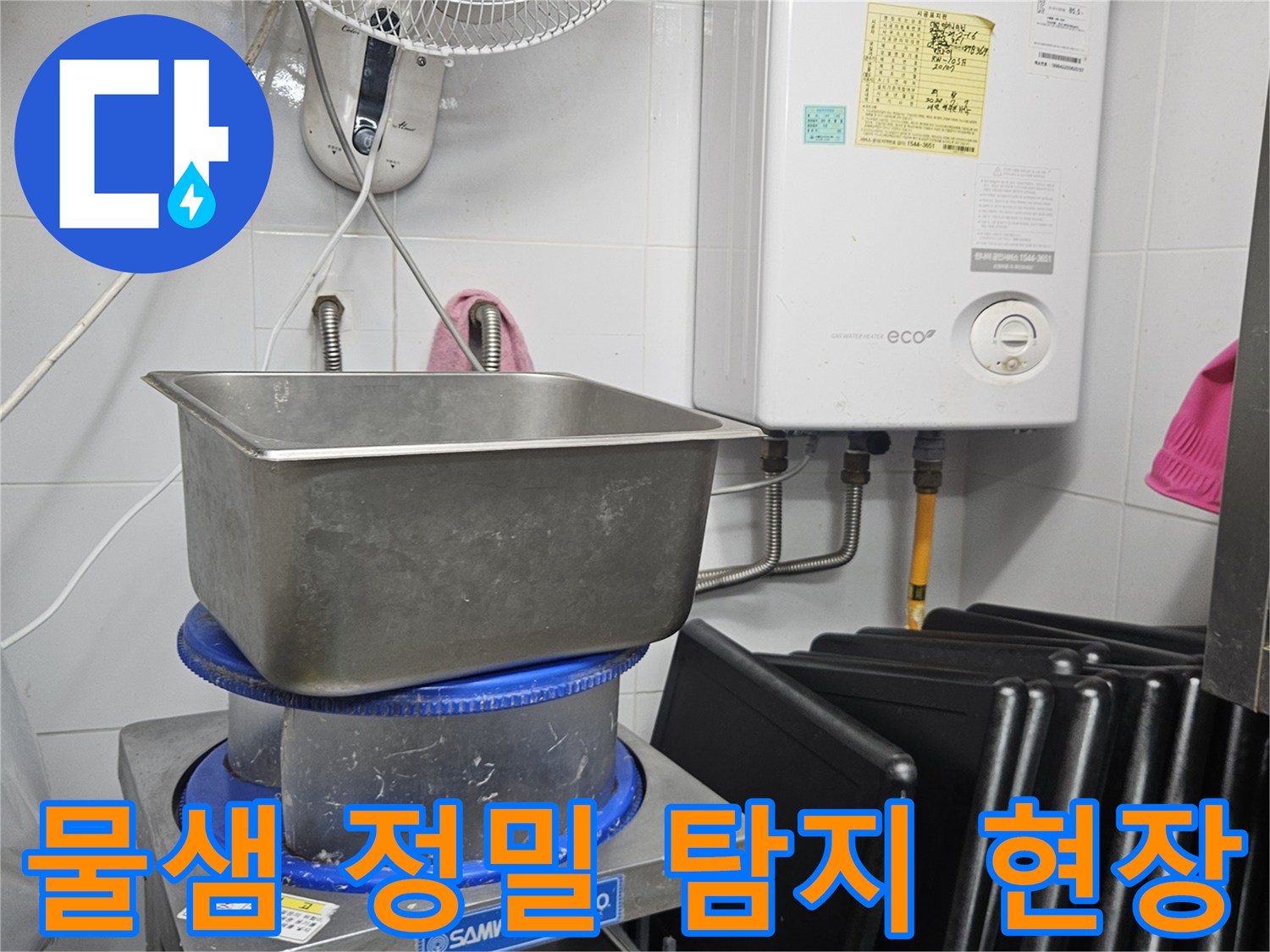 이 이미지는 보일러와 싱크대-그리고 다양한 배관이 있는 공간에서-물샘 현상의 원인을 찾기 위해 정밀 탐지 작업을 수행하는 모습을 담고 있습니다.