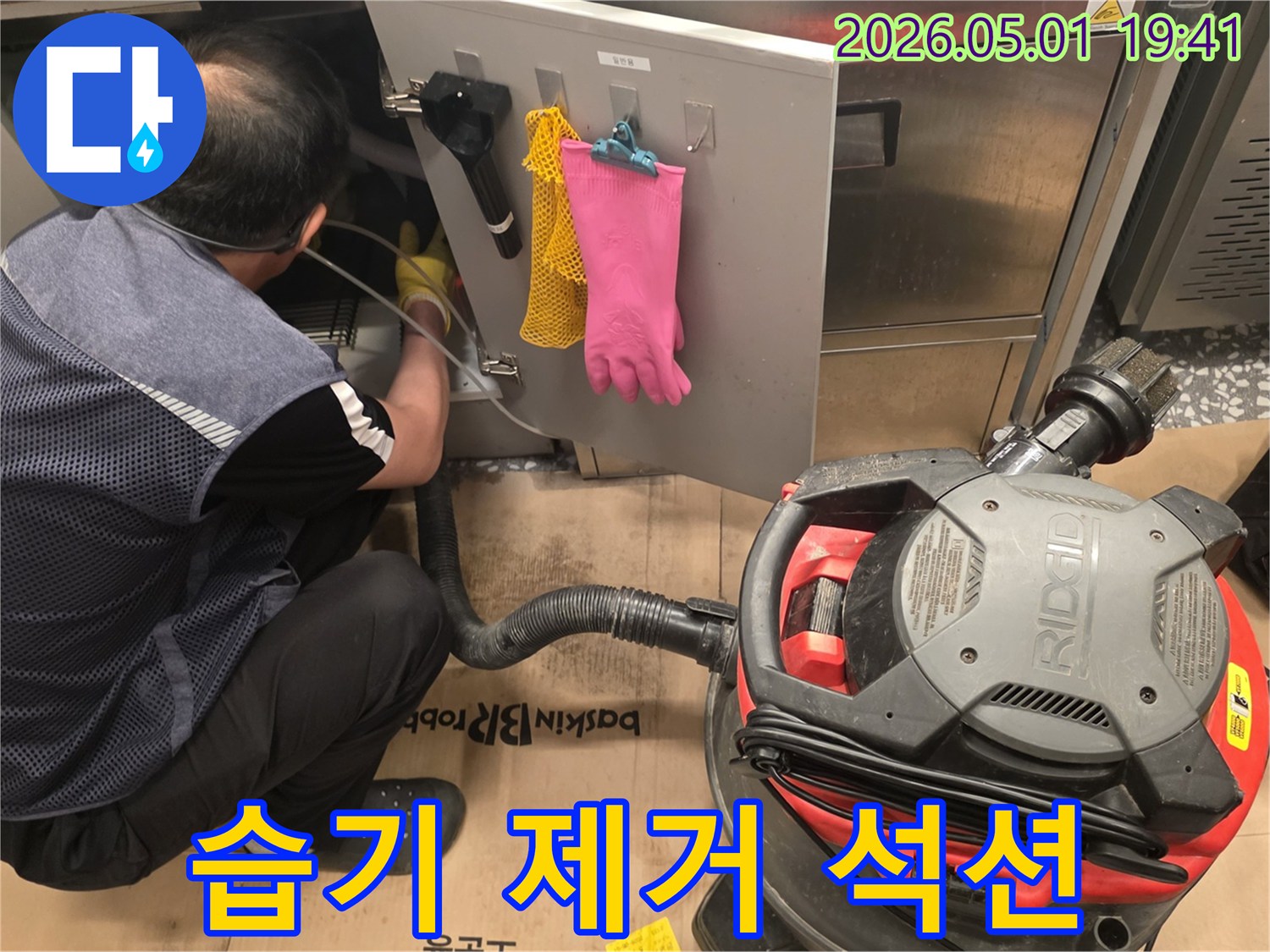 습기-제거를-위해-산업용-청소기를-사용하여-누수-현장을-정리하는-모습