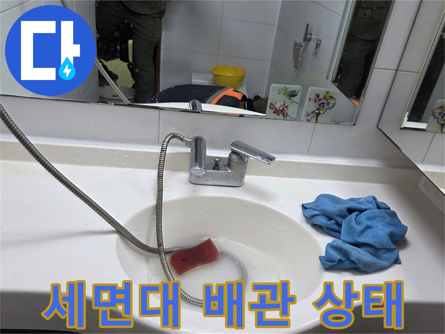 세면대 하단 샤워 호스와 수전의 결합 부위 사진입니다.