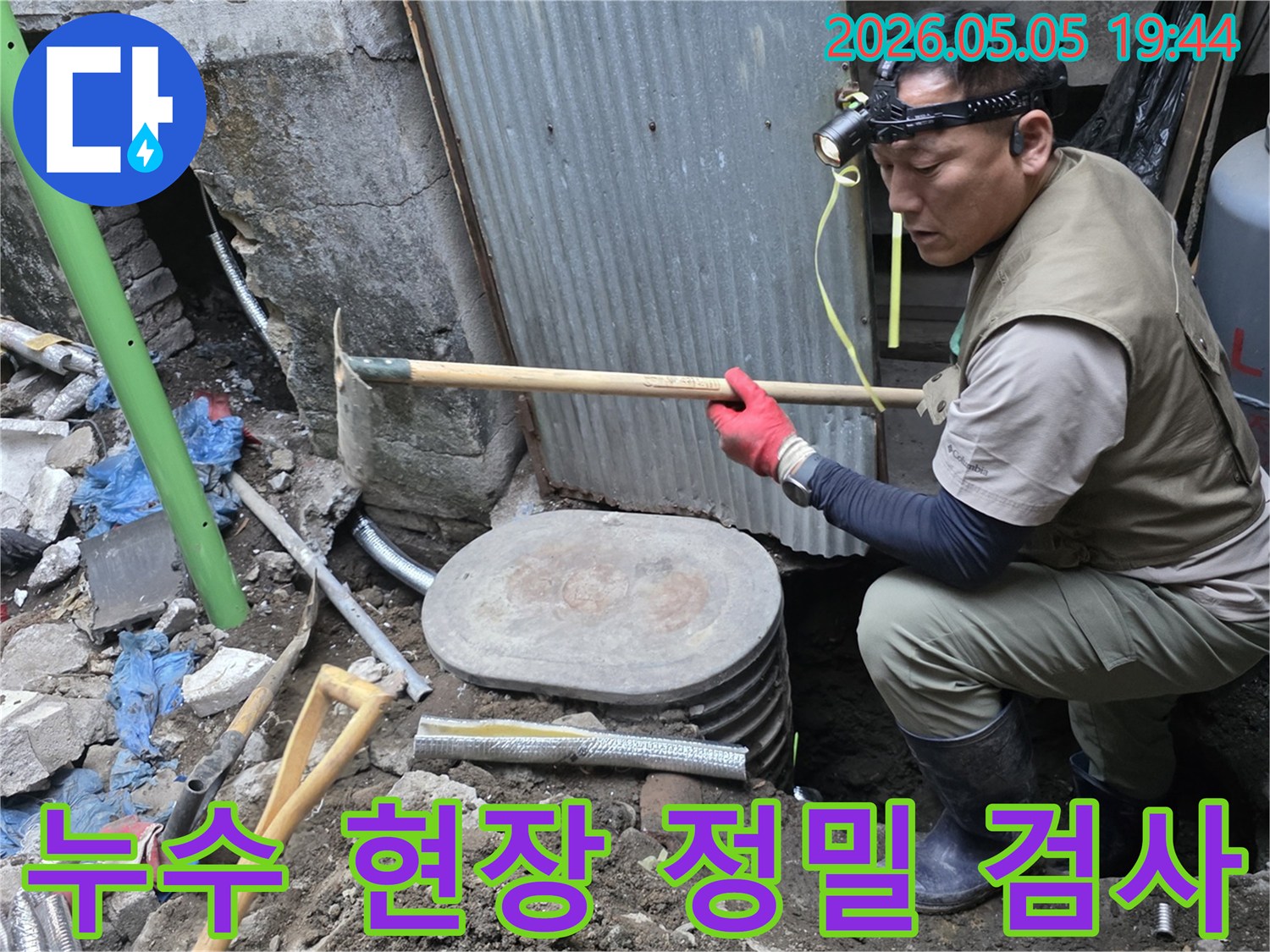 헤드램프를 착용한 작업자가 땅속에 매설된 수도관의 누수 여부를 꼼꼼히 점검하고 있습니다