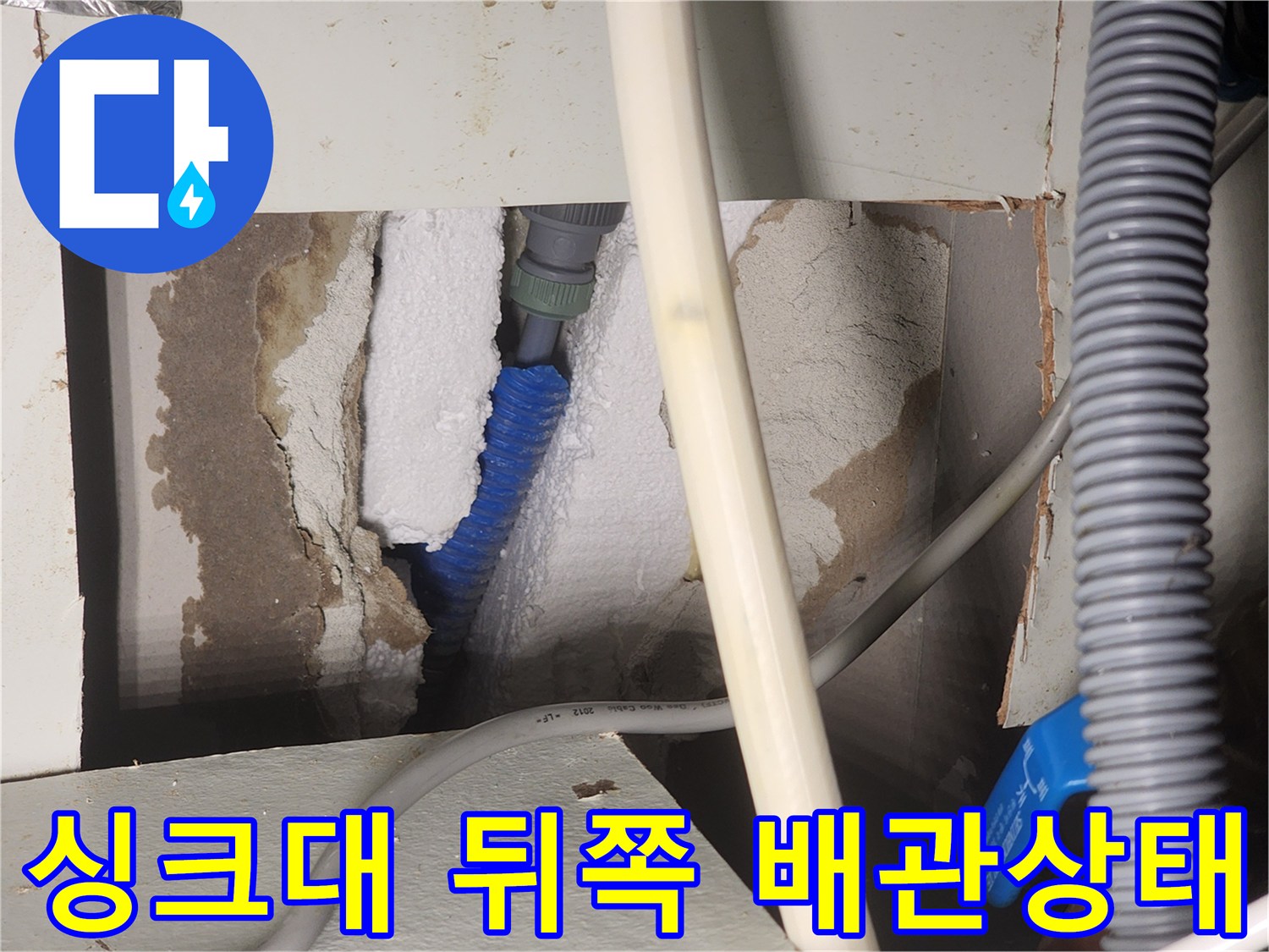용인 수지구 현장의-싱크대 하부장 내부 벽체와 파란색 온수 배관 모습
