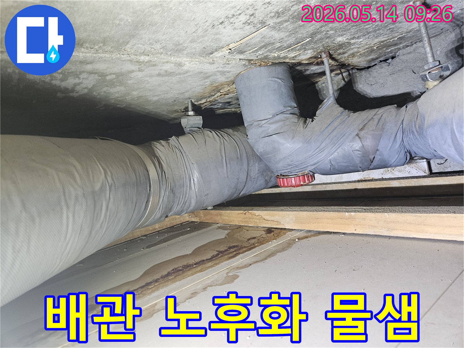 콘크리트 천장과 보온 배관 사이에서 발생한-누수로 인해 바닥에 물이 고이고 얼룩이 진 현장 모습
