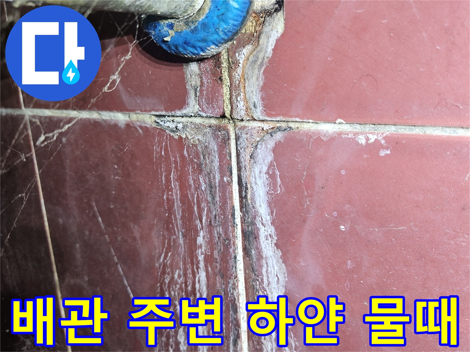 화장실 배관 연결 부위의 하얀 석회 침전물과 습기 흔적