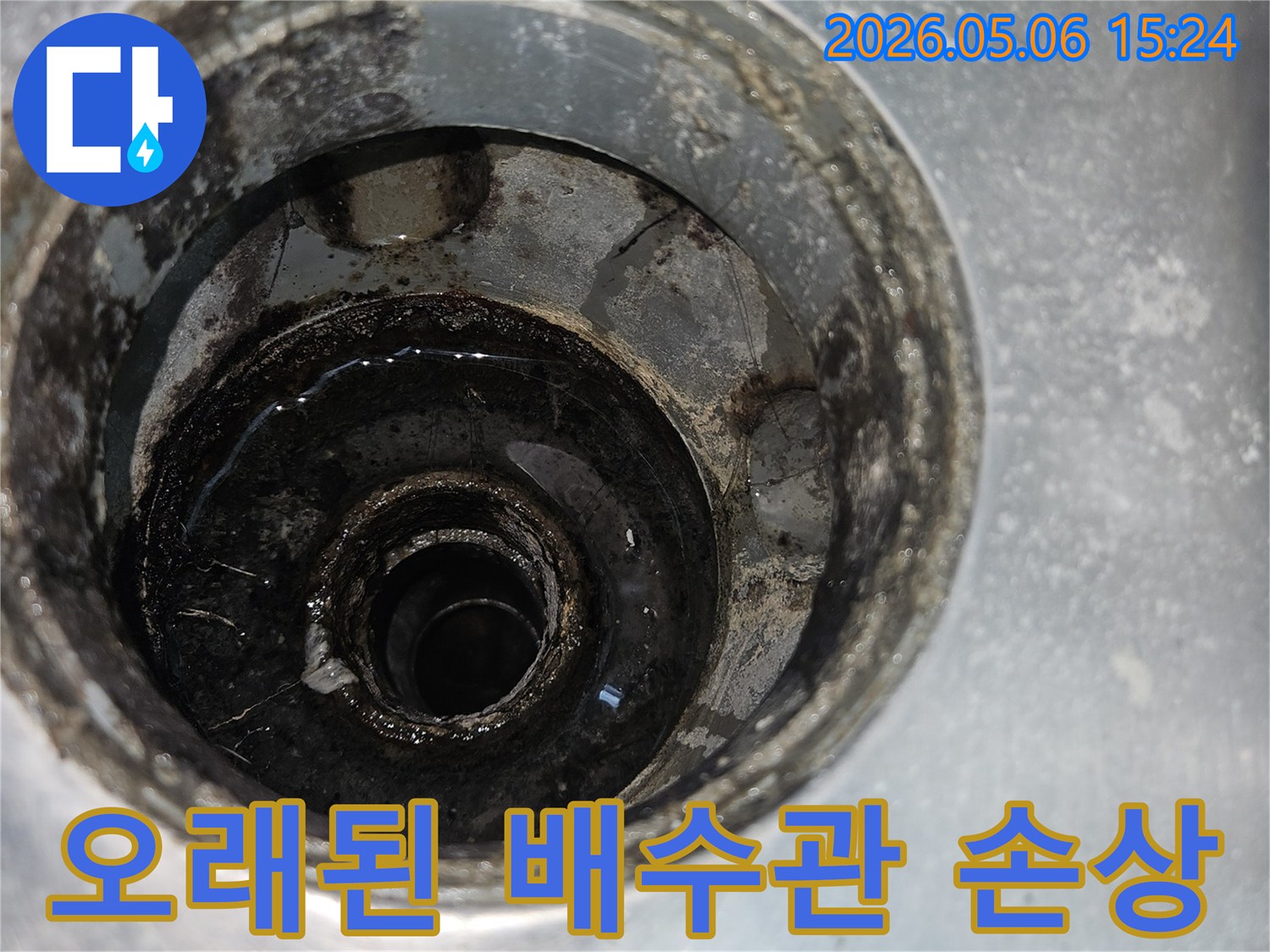 오랜 사용으로 인해 심하게 손상되고-부식된 배수관의 내부 상태를 보여주는 사진입니다.