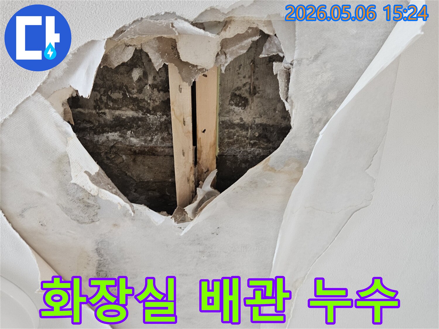 화장실 배관 누수로 인해 천장 벽지가 젖고-뜯겨져 내부 구조물이 드러난 심각한 피해 현장입니다.
