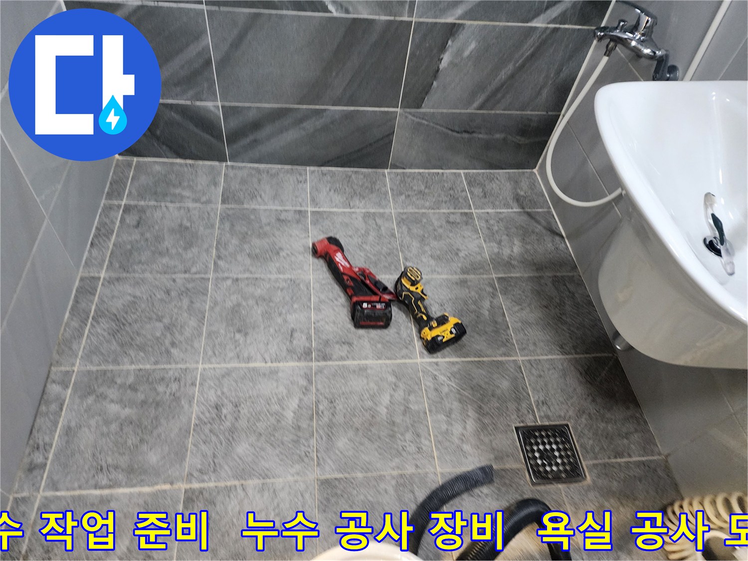 화장실 누수 공사를 위해-바닥에 가지런히 놓인-전문 작업 도구들의 모습입니다.