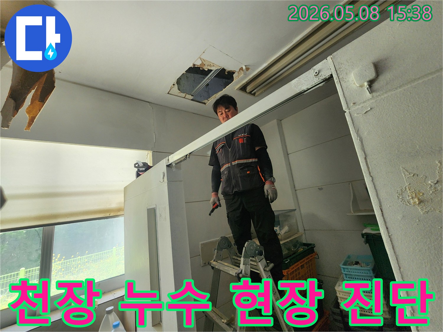 누수 엔지니어가 사다리 위에서-천장 손상 부위를-집중적으로 살피고 있습니다