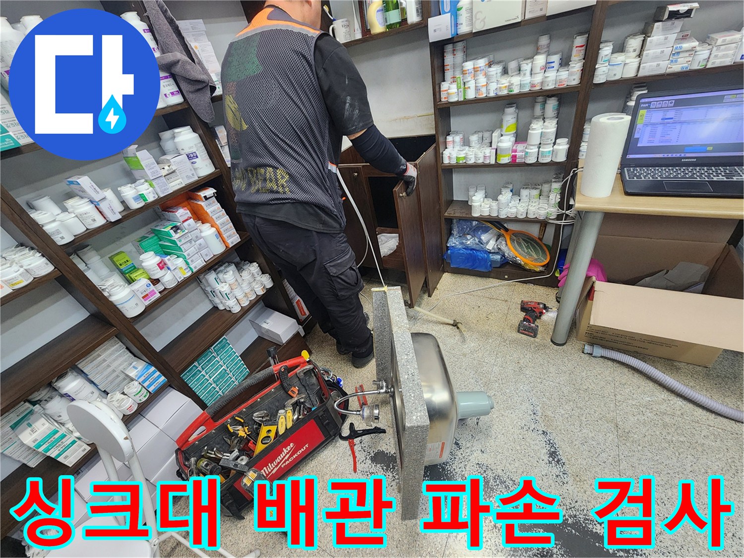 싱크대 배관 파손으로 인한 누수 원인을 확인하기 위해-전문 엔지니어가 싱크대를 안전하게 분리하고 검사하는 모습