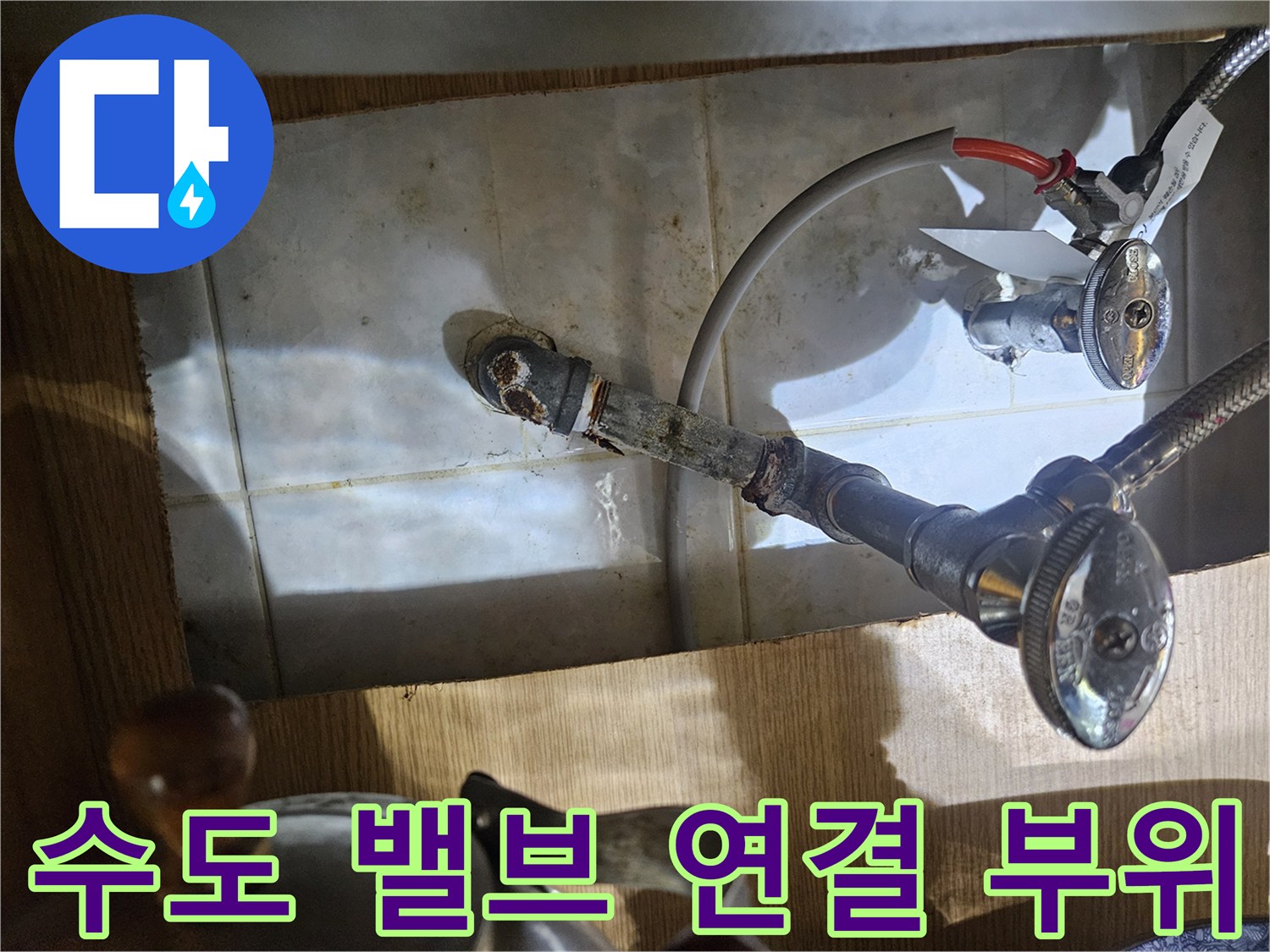 벽면 타일 근처에 위치한 수도 배관과 제어 밸브