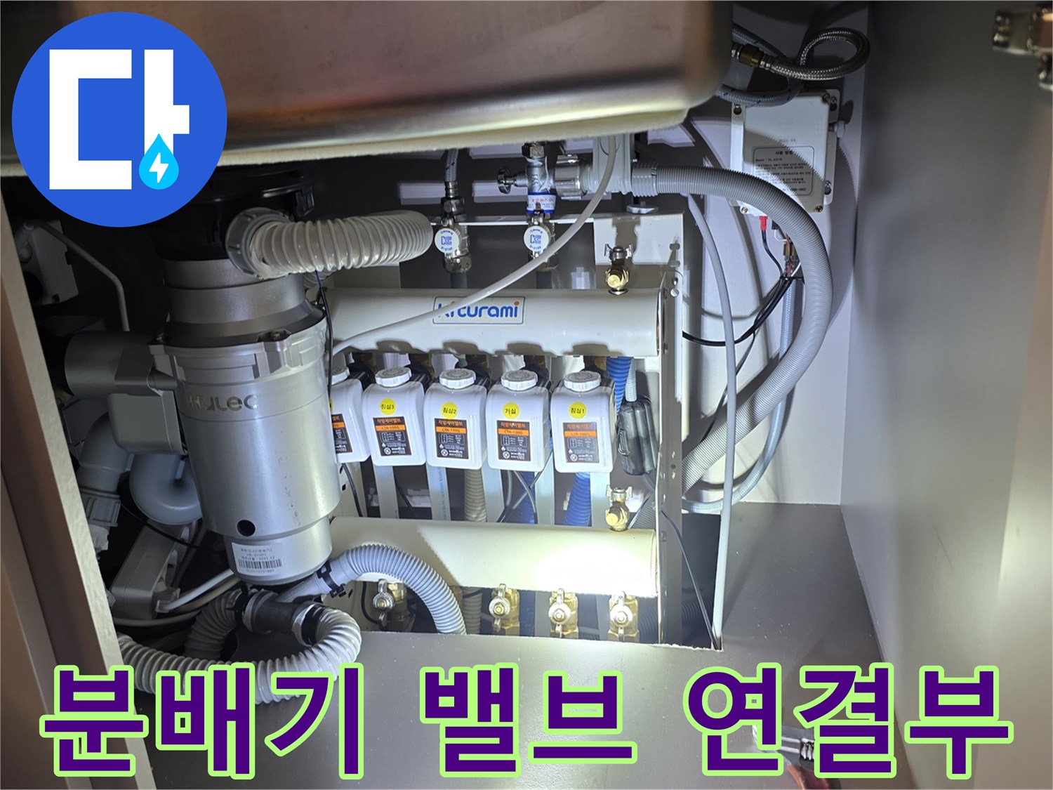 싱크대 하단에 위치한 귀뚜라미 분배기와 여러 가닥의 배관들