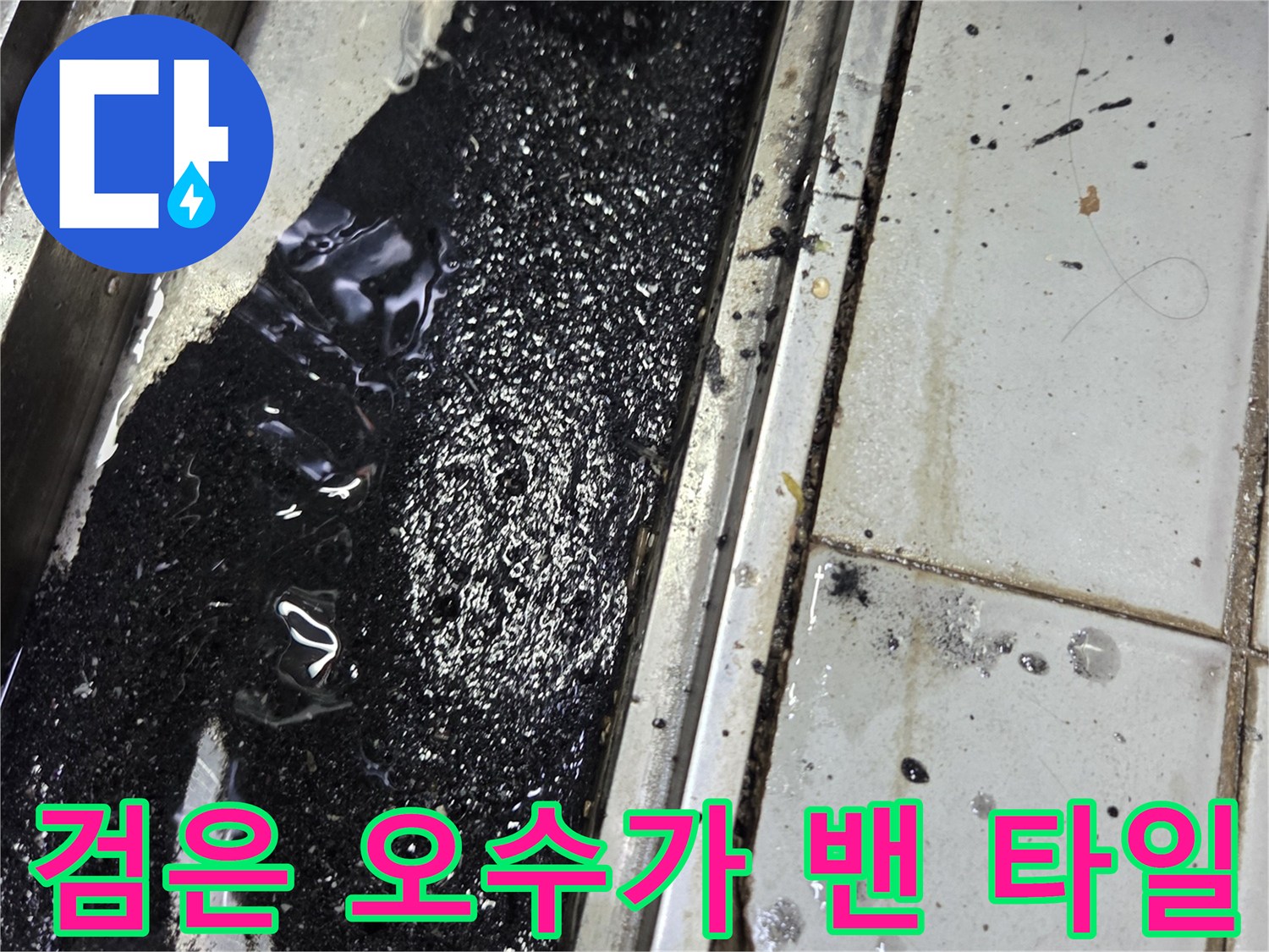 타일 사이로 흘러나온 검은색 액체와 배관 연결 부위