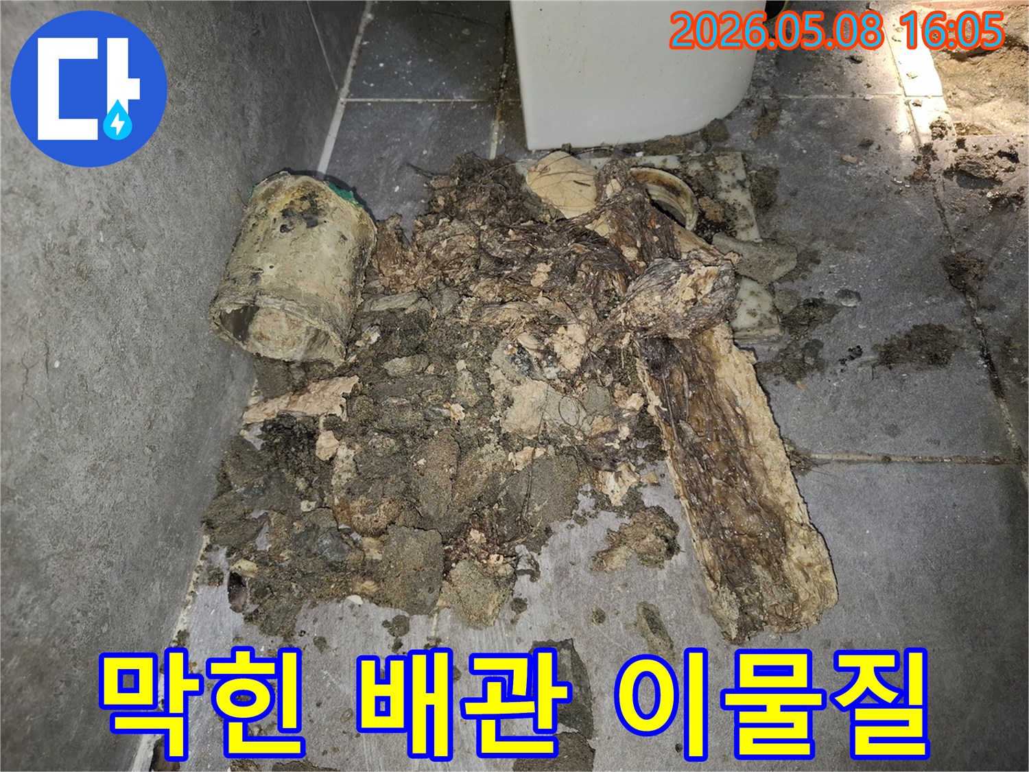 이 이미지는 막힌 배관에서 제거된-오물과 슬러지 덩어리를 보여줍니다-막힌 배관의 심각성을 나타냅니다.