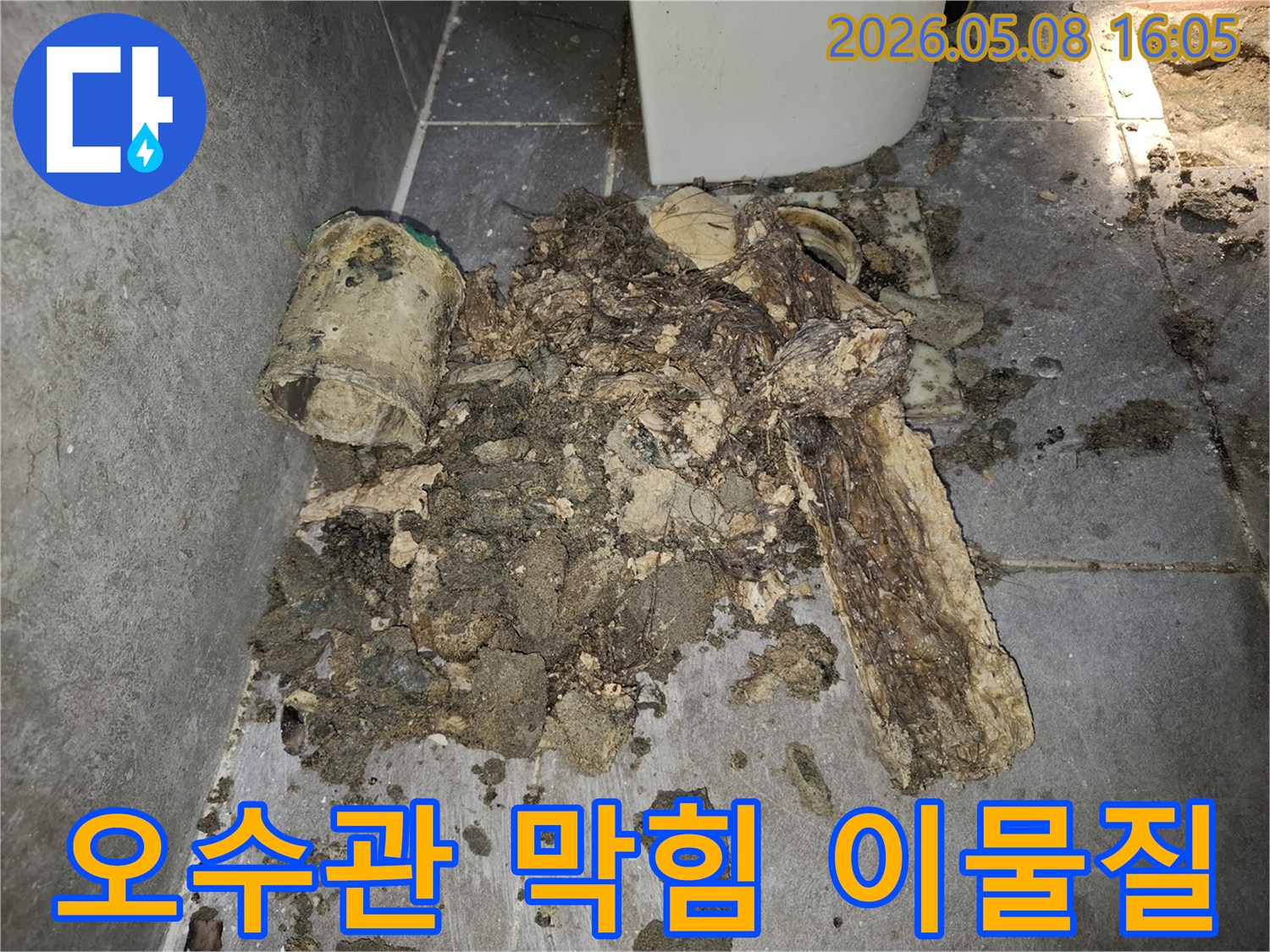 이 이미지는 오수관에서 제거된-오랜 기간 쌓인 오물과-슬러지 덩어리를 보여줍니다-오수관 막힘의 심각성을 나타냅니다.