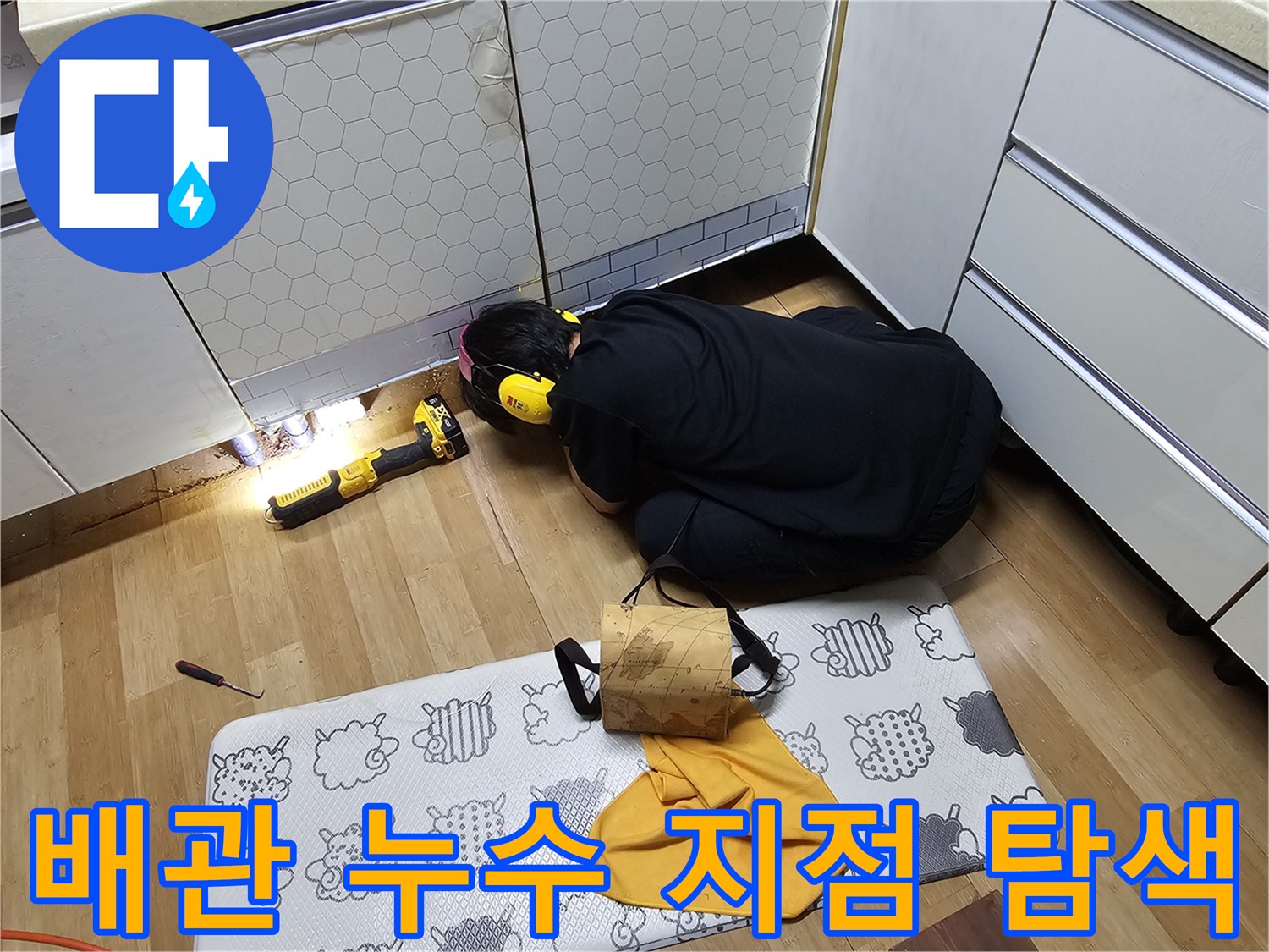 전문 장비를 활용하여 싱크대 하단 배관의 누수를 찾아내는 작업 장면