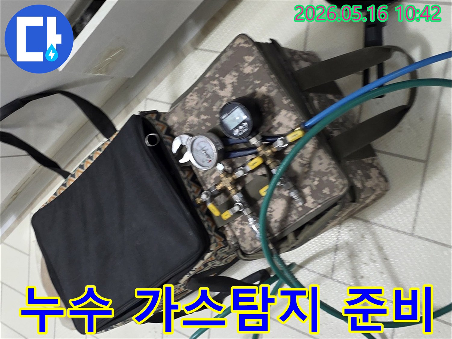 배관 누수 지점을 찾기 위해-가스 탐지 장비를 연결하고 있는 장면입니다.