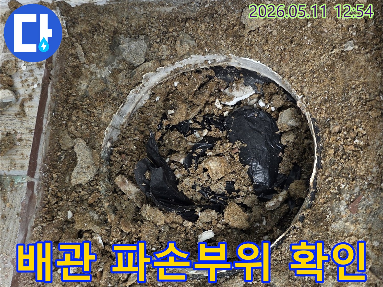 바닥을 파쇄하여 누수 지점의 배관 파손 여부를 확인하는 공사 현장 사진입니다.