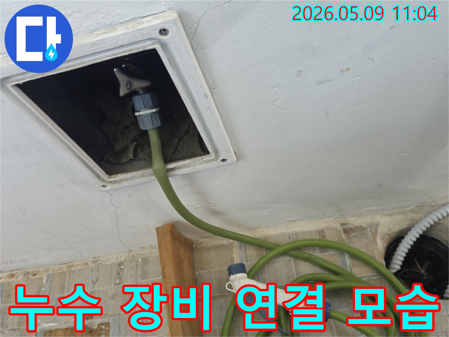 천장 점검구에 누수 탐지 장비 호스를 연결하여 내부를 정밀하게 검사하는 중요 과정