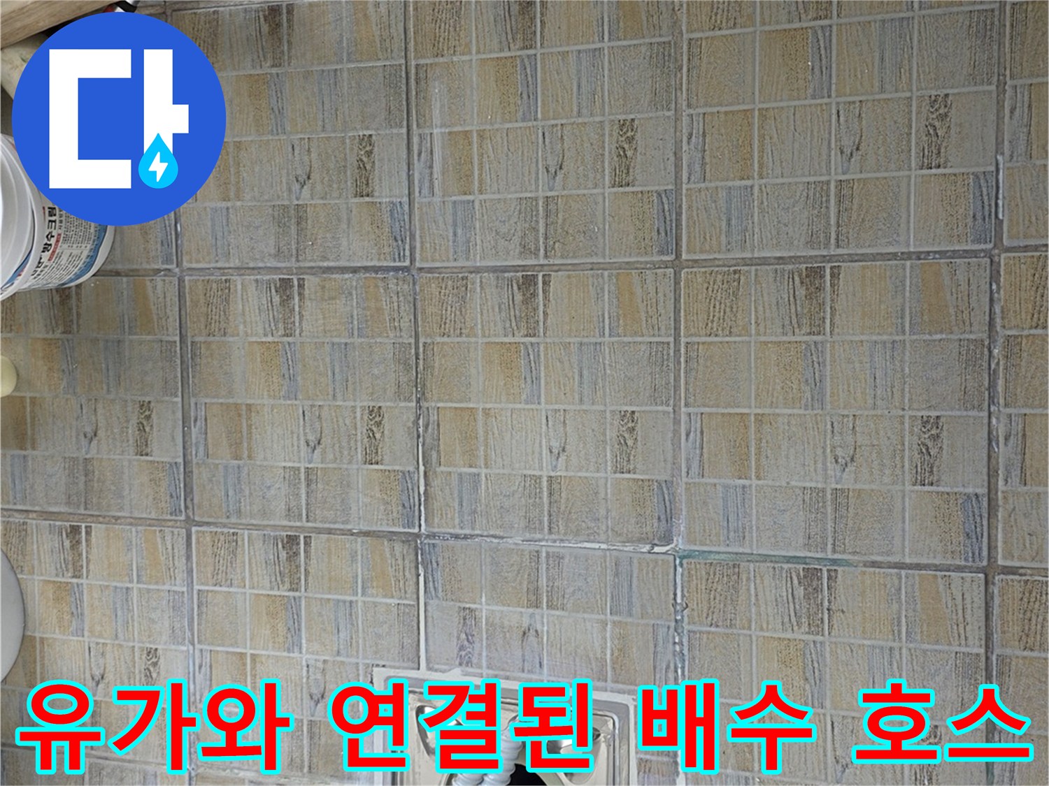 하얀색 배수 호스와 금속 유가가 결합된 부분의 모습입니다.