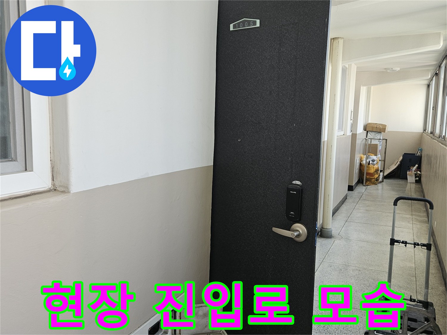 아파트 복도 끝에 위치한 작업 현장의 출입문 전경입니다.