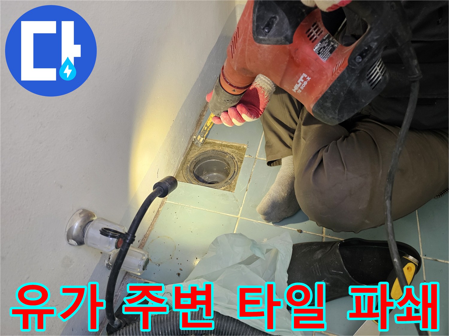 배수구 유가 근처의 타일을 드릴로 걷어내는 공사 현장 사진