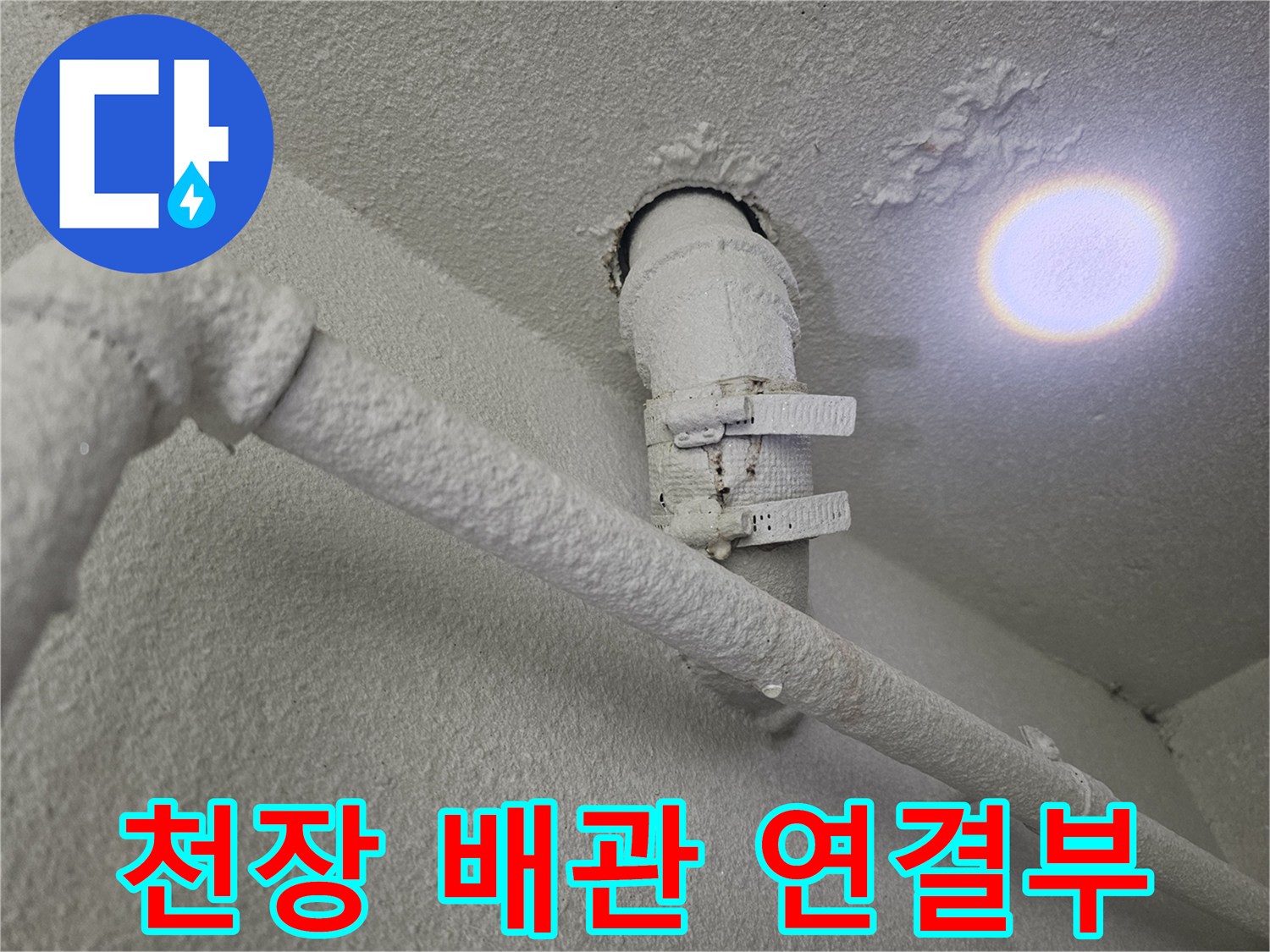천장에 설치된 배수 파이프와 고정용 클램프를 촬영한 이미지입니다.