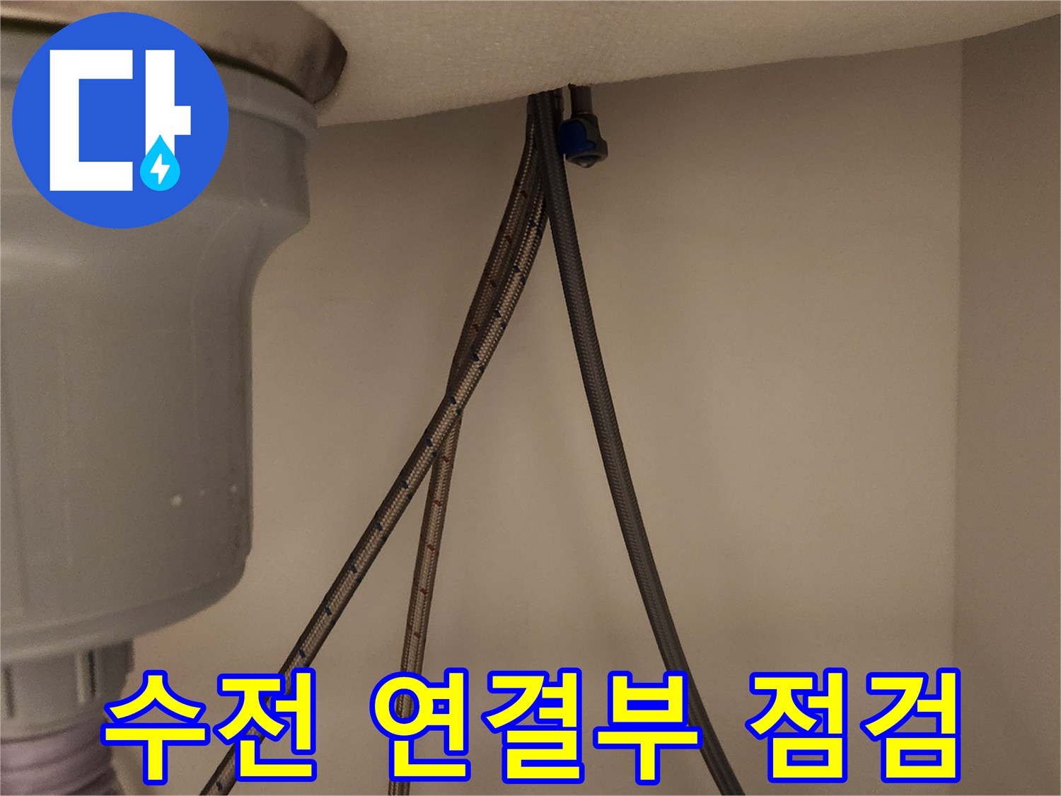 싱크대 아래에서 노후된 수도꼭지의 급수관 연결 부위를 면밀히 점검하는 모습입니다.