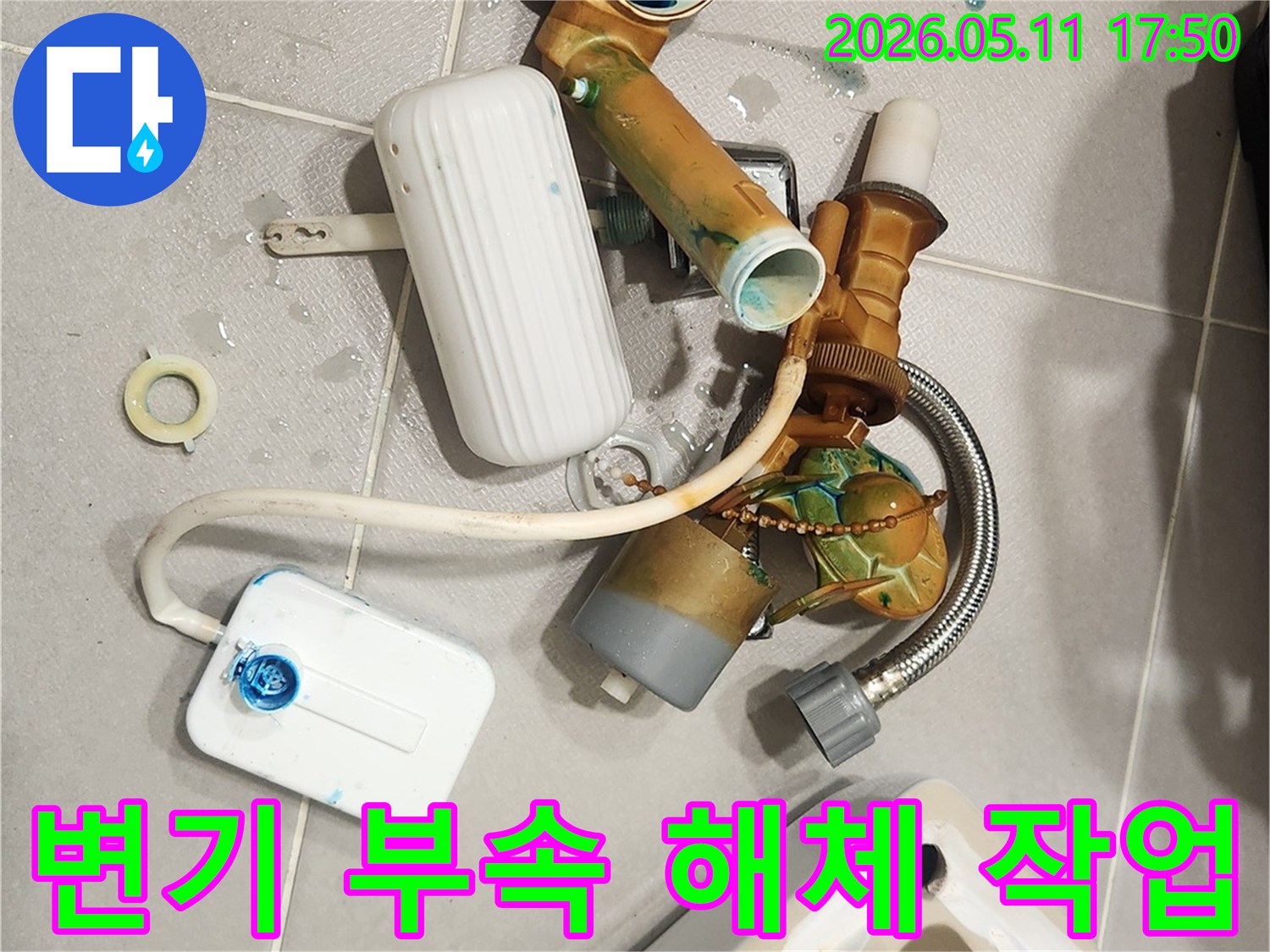 안방 변기에서 발생한 물샘 문제를 해결하기 위해-오래된 변기 부속들이 해체되어 바닥에 놓여 있는 모습입니다-새 부품으로 교체하여 변기를 수리할 예정입니다